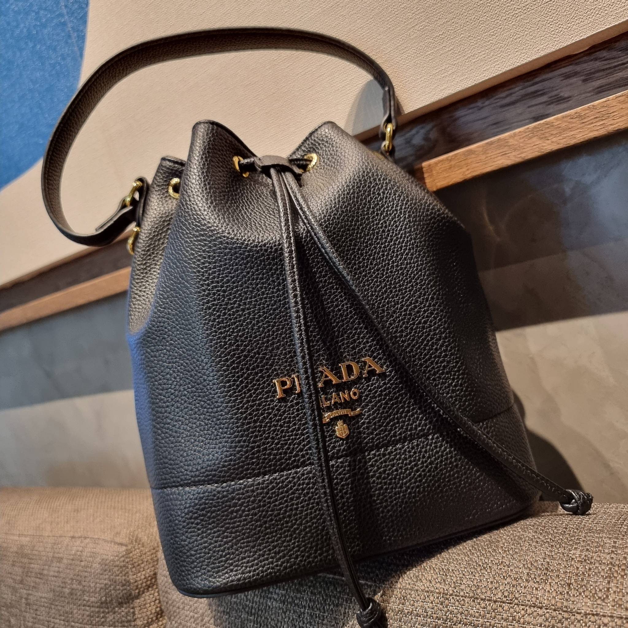 Prada leather bucket bag กระเป๋าสะพายทรงขนมจีบ ดีไซน์เรียบ แต่หรู น่าใช้มากๆ หนังสวยมาก วัสดุหนัง pepble สัมผัสนิ่มมือ ตกแต่งโลโก้สีทองตัดหนังดำ คือเลิศ!! ปากกระเป๋ารูดเปิดปิดได้ สะดวกใช้งาน ภายในโล่งกว้าง จุของได้เยอะ ไม่ธรรมดาเลย พิเศษ!! นอกจากสายคล้องใ
