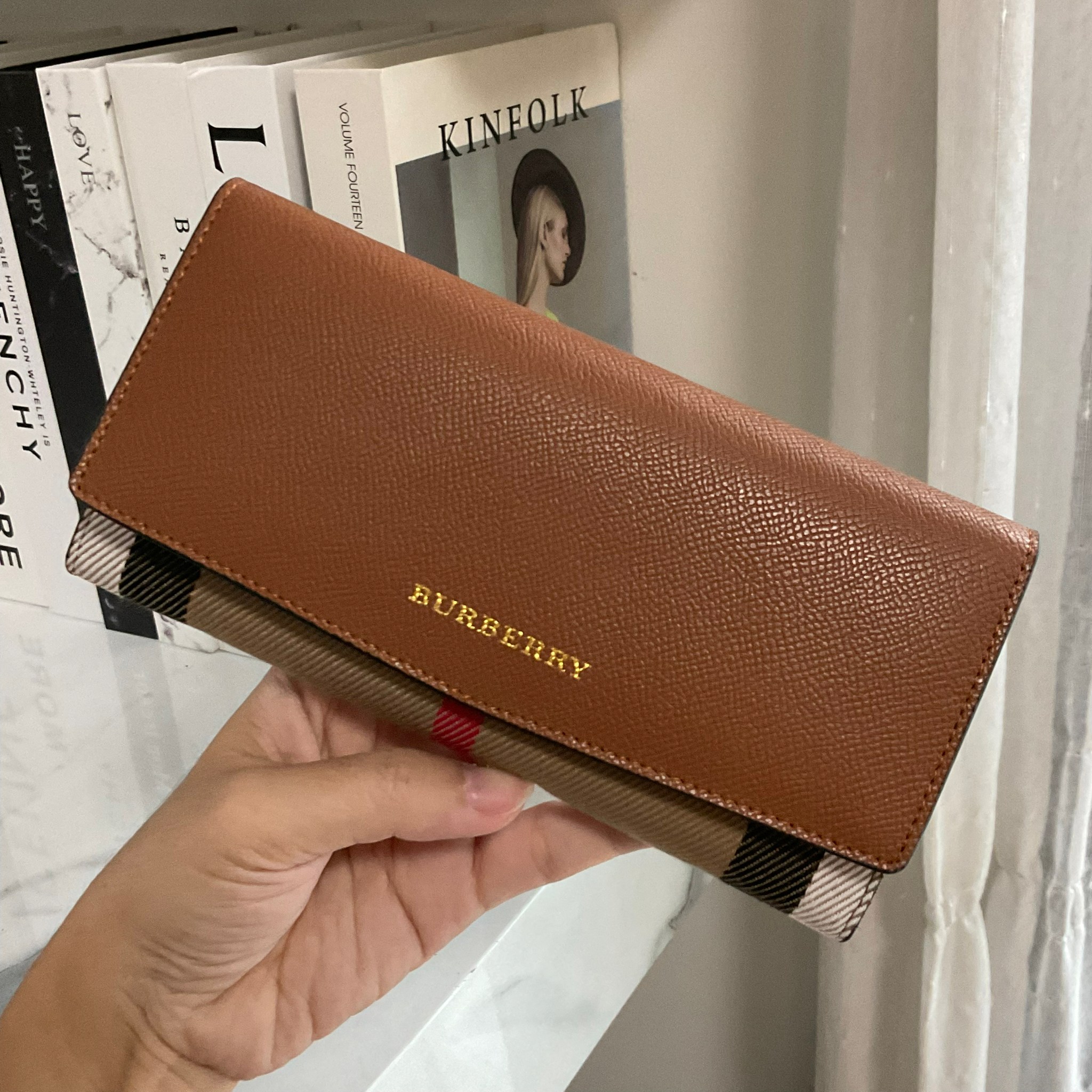 กระเป๋าสตางค์รับทรัพย์ ทรงหรู จากงาพรีเมี่ยมกิ๊ฟ Limited Edition จาก BURBERRY กระเป๋าสตางค์ใบยาวแบบพับกระดุม ทูโทนด้วยหนังแท้คาดผ้าลาย vintage ด้านในมีช่องใส่ธนบัตรยาวทั้งสองฝั่ง ช่องใส่บัตรได้อย่างน้อย 12 ช่อง และช่องเปิดด้วยซิปปั้มแบรนด์อะไหล่ทองสุดหรู 