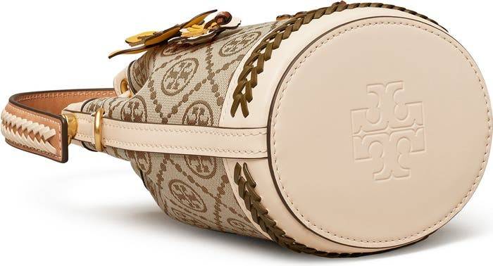 TORY BURCH MINI T MONOGRAM FLORAL BUCKET BAG คอลเลคชั่นใหม่ พร้อมเสิร์ฟความสวยให้ถึงบ้าน!! กระเป๋าบัคเก็ตทรงยอดนิยม ไซส์มินิ ดีไซน์ใหม่ล่าสุด สไตล์งานคราฟ มีลูกเล่นประดับดอกไม้กับตัวกระเป๋า และตัวรูดสาย วัสดุผ้า jacquard ตัดสลับหนังแท้ หูจับและขอบกระเป๋าต