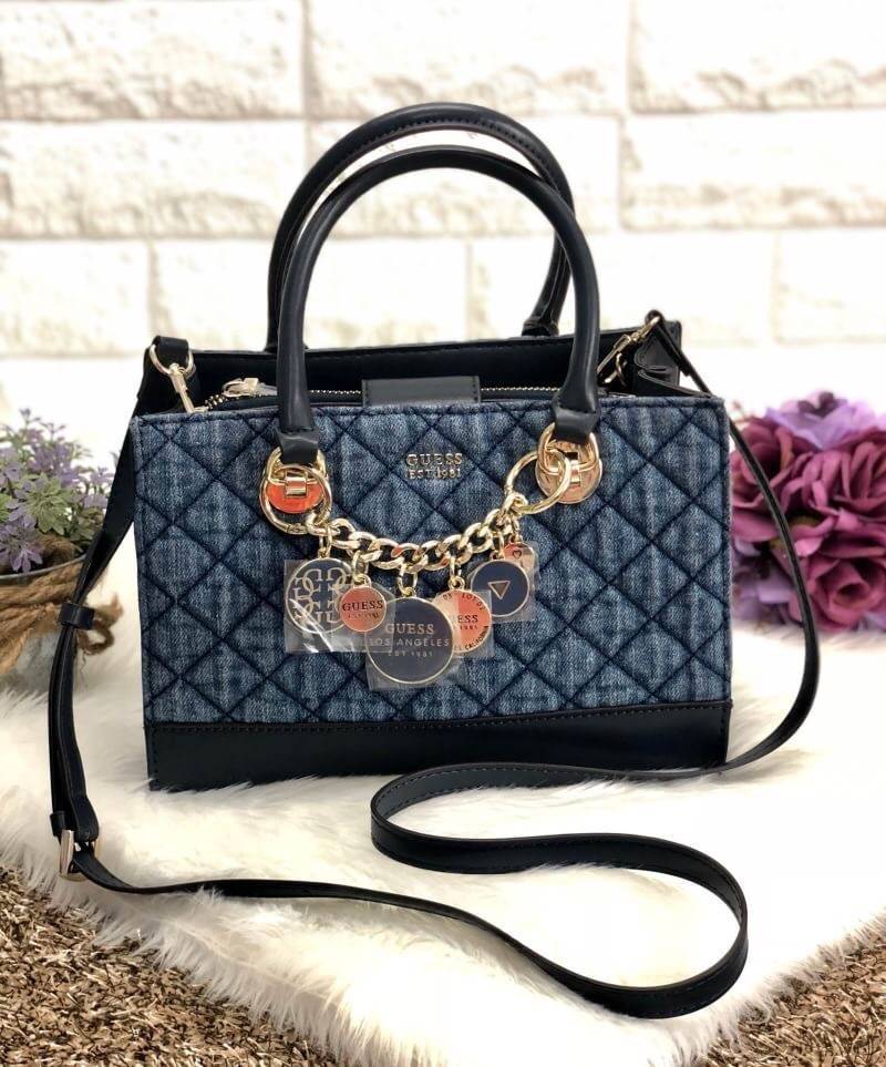 New arrival !! GUESS VICTORIA SATCHEL BAG 2018 หรูส่งท้ายปี รุ่นหายาก กระเป๋าถือหรือสะพายข้างได้ วัสดุเดินด้ายลายนวม นิ่ม น้ำหนักเบา ด้านหน้าห้อยอะไหล่แบรนด์เพิ่มความหรู ปากกระเป๋ามีกระดุมแม่เหล็ก แบ่ง 3 ช่อง สามารถใส่กระเป๋าสตางค์ใบยาวได้ มีช่องซิปคั่นกล