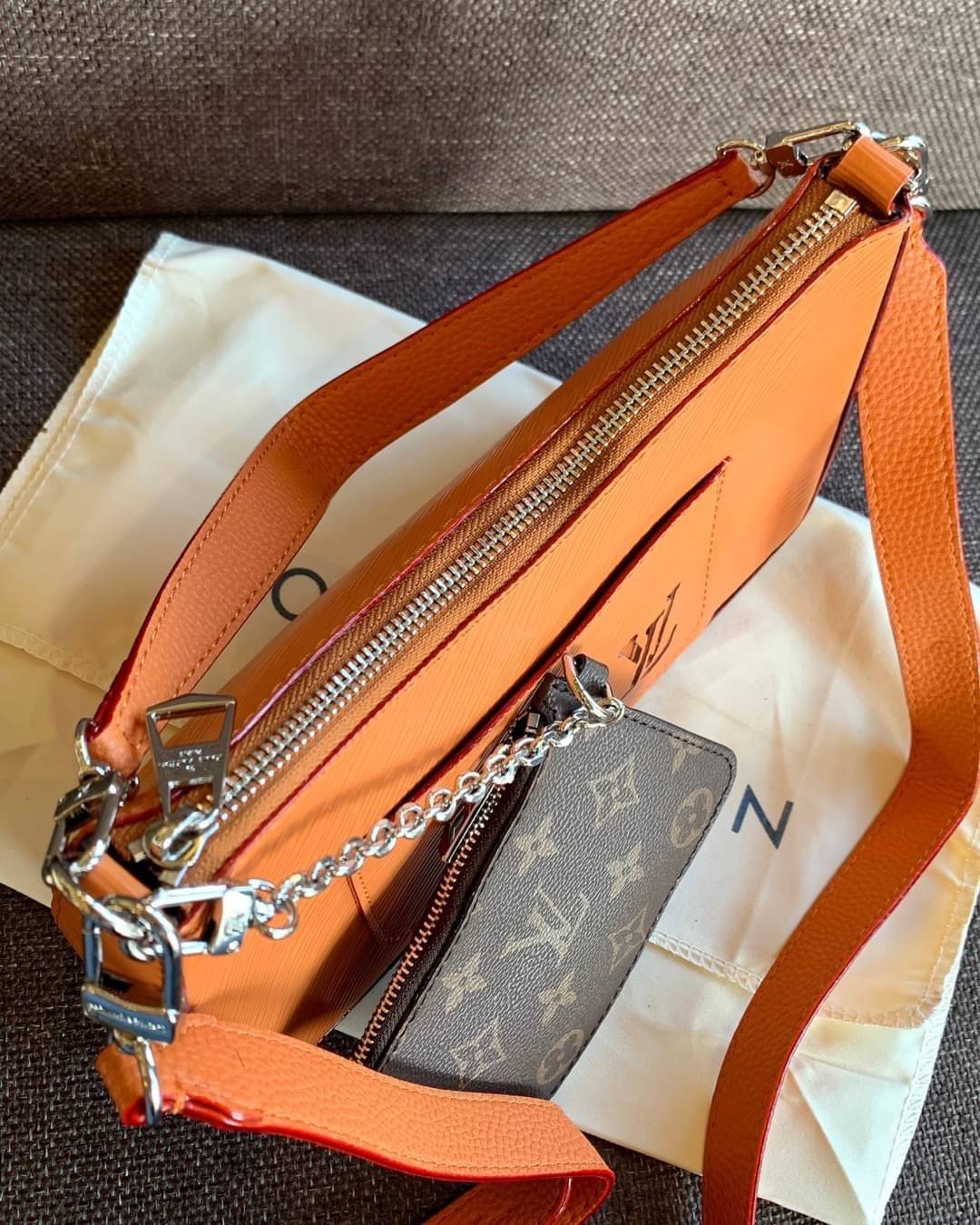 VIP 🥂 LOUIS VUITTON MARELLR EPI LEATHER รุ่นนี้ลายหนังเป็นลายไม้ มีโลโก้แบรนด์แบบฉลุด้านหน้า มาพร้อมกระเป๋าใบลูกแบบซิปจัดเก็บได้ตรงช่องด้านหน้า สามารถถอดออกแยกใช้งานได้ต่างหากนะคะ เปิดปิดกระเป๋าแบบซิป ภายในโล่ง สามารถใส่กระเป๋าเงินใบยาวได้;ของจุกจ