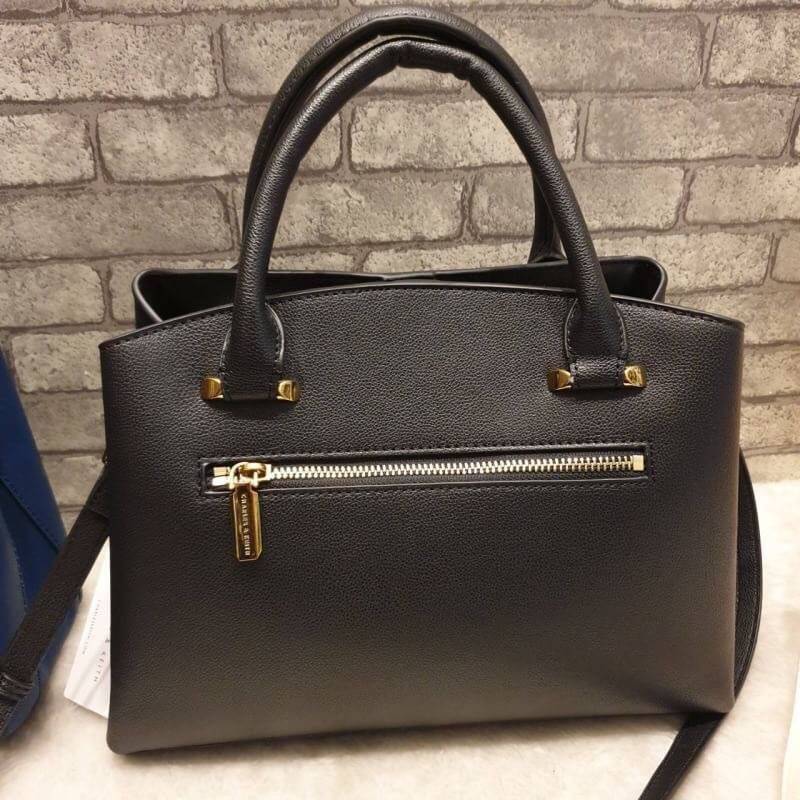 CHARLES & KEITH CLASSIC TOP HANDLE BAG กระเป๋าถือหรือสะพายใบใหญ่ ทรงแข็ง หนัง pu สวย ดีไซน์เรียบหรู ดูดี ด้านหน้าป้ายโลโก้แบบนูน ด้านหลังมีซ่องซิป 1 ช่อง เปิด-ปิดแบบกระดุมแม่เหล็ก ภายในมี 2 ช่องใหญ่ คั่นกลางด้วยช่องซิป มีหมุดรองรองฐานสี่มุม มาพร้อมสายสะพา