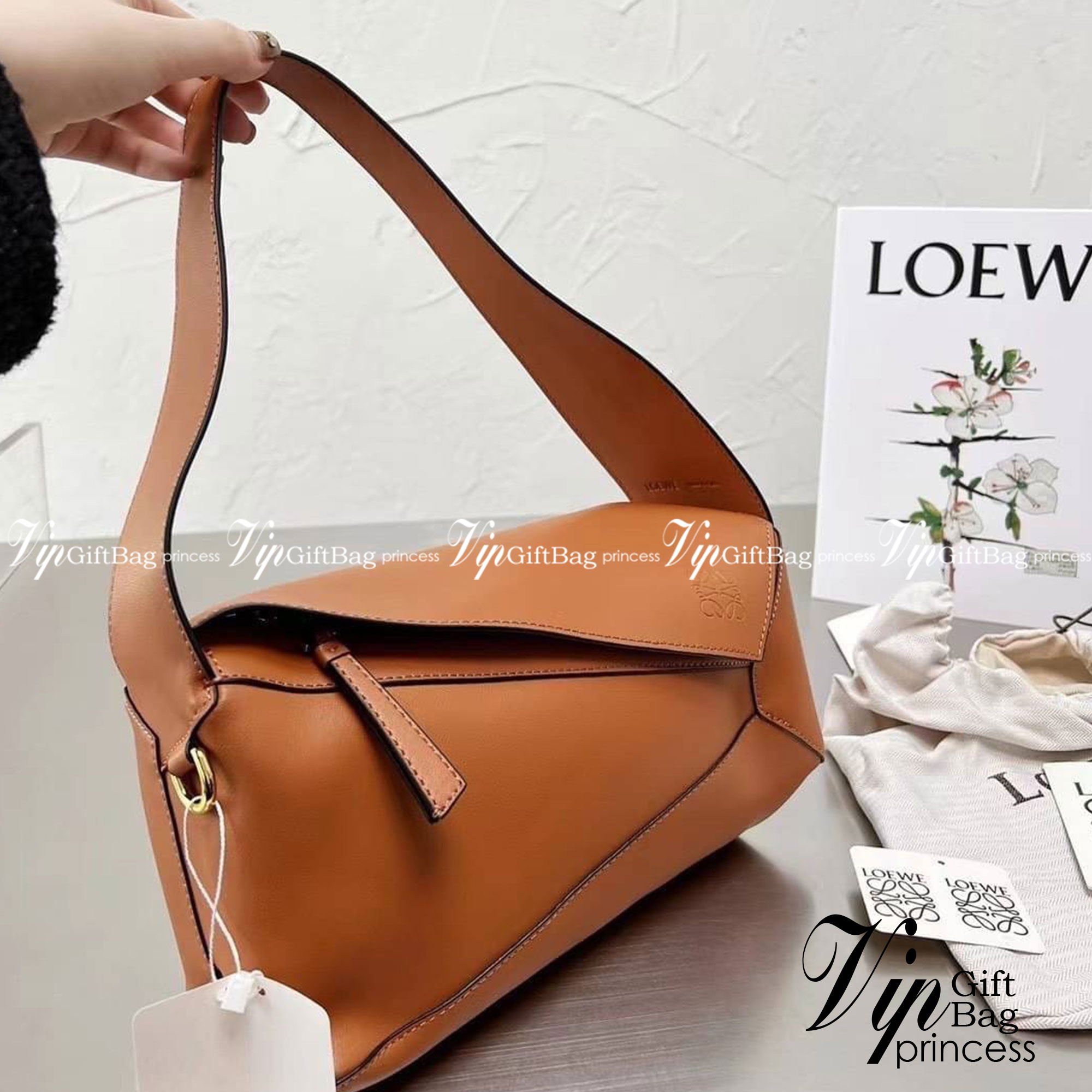 LOEWE Puzzle Hobo bag in nappa calfskin กระเป๋าสะพายไหล่มีความพิเศษในหลายด้าน ไม่ว่าจะเป็นรูปทรงที่แปลกใหม่ มินิมอลด้วยโลโก้อนาแกรมแบบประทับ ดูหรู เป็นกระเป๋า Unisex ที่ไม่ว่าคุณจะเป็นผู้หญิงหรือผู้ชายก็ใช้งานได้