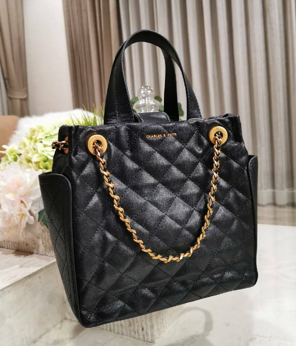 CHARLES & KEITH HANDBAG กระเป๋าถือหรือสะพายดีไซน์สวยหรูวัสดุหนังคาเวียร์อยู่ทรง ด้านหน้ามีโลโก้ ด้านข้างมีช่องใส่ของ มีหูจับถนัดมือ พร้อมสายสะพายโซ่มีที่รองบ่าสามารถใช้สายคู่สะพายไหล่หรือสายเดี่ยว Crossbody ได้ มีหมุดรองฐานกันรอย ภายในมีช่องซิปเเละช่องใส่