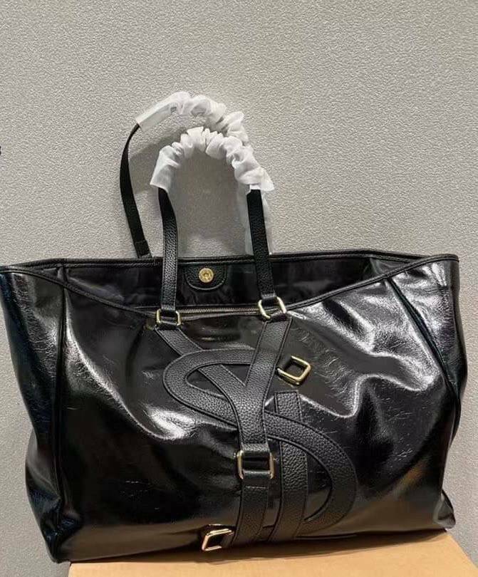 YSL Vavin Tote in Black Classic Leather / YSL SHOPPING E/W IN SUPPLE LEATHER รุ่นหนังเงา กระเป๋าทรงโท้ทใบใหญ่ หน้าโลโก้ใหญ่โดดเด่น ช่องกว้างใช้งานง่าย ภายในโล่งกว้างมาก ใส่ของได้สบาย หิ้วไปเที่ยวต่างจังหวัด สะพายไปต่างประเทศตามใจ!! เลิศตรงที่ดีไซน์ใบนี้เป