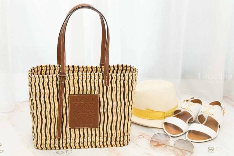 LOEWE X PAULA'S IBIZA SMALL SQUARE BASKET BAG กระเป๋าสะพายไหล่จากโลเอเว่ เป็นกระเป๋าสานขึ้นจากใบกก (Reed) ที่มีทั้งความเหนียวและความยืดหยุ่น สวยน่ารักแบบมินิมอล มีความทนทานสูง ดูแลรักษาง่าย ด้านหน้าและหูเป็นหนังแท้(calf skin) ส่วนภายในมีถุงผ้าแบบหูรู