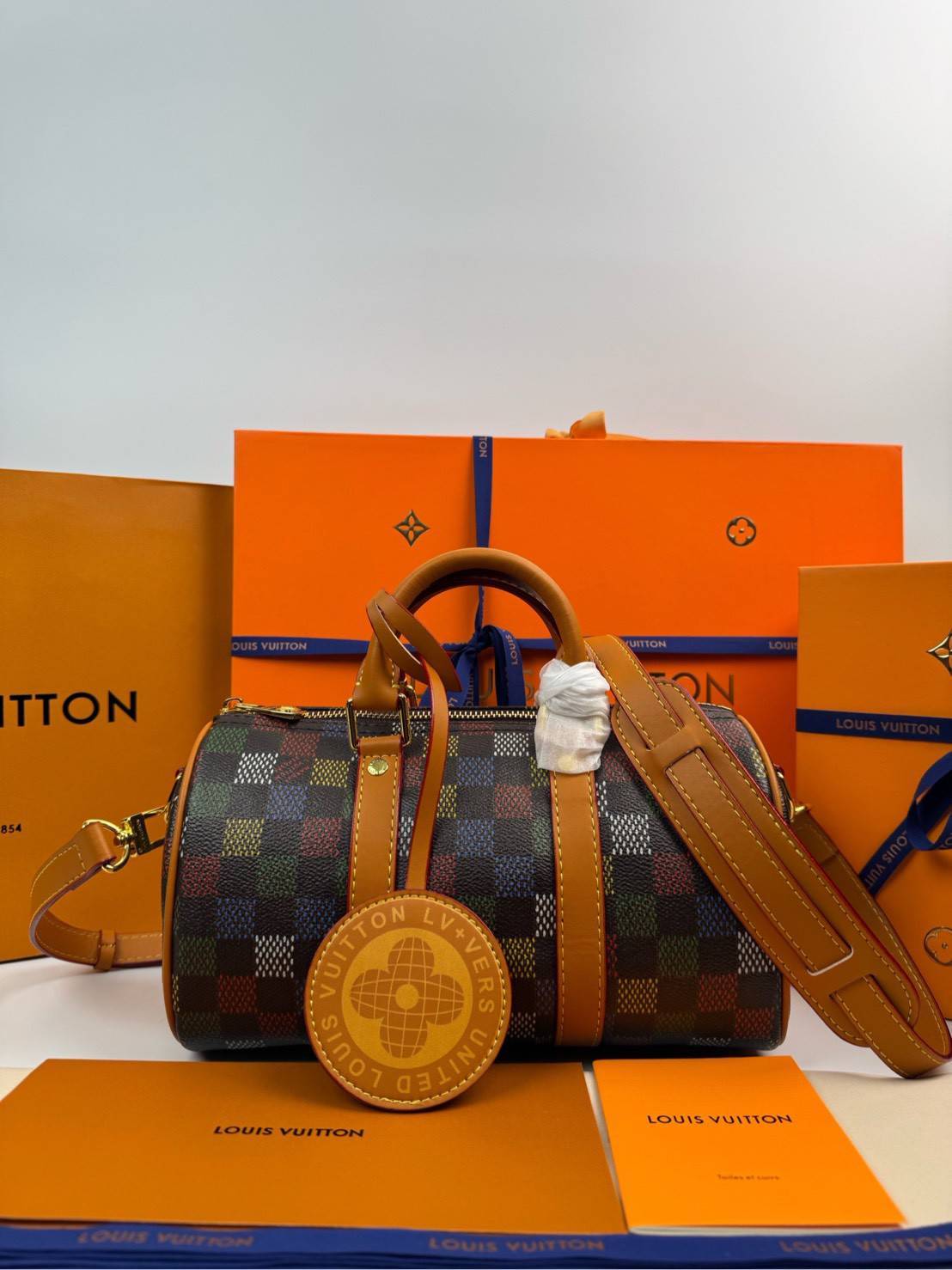 ORI หนังแท้ | LV Keepall Bandoulière 25 Bag กระเป๋าทรงหมอนซิตี้ ดีไซน์ใหม่จาก LV Vers Damier Ebene โดดเด่นที่ลายช่องสี่เหลี่ยมดุจระบายสีด้วยมือพิมพ์ลงบนลายตารางหมากรุก แต่งดีเทลหรูหราผสานอดีตเข้ากับปัจจุบันได้อย่างมีสไตล์