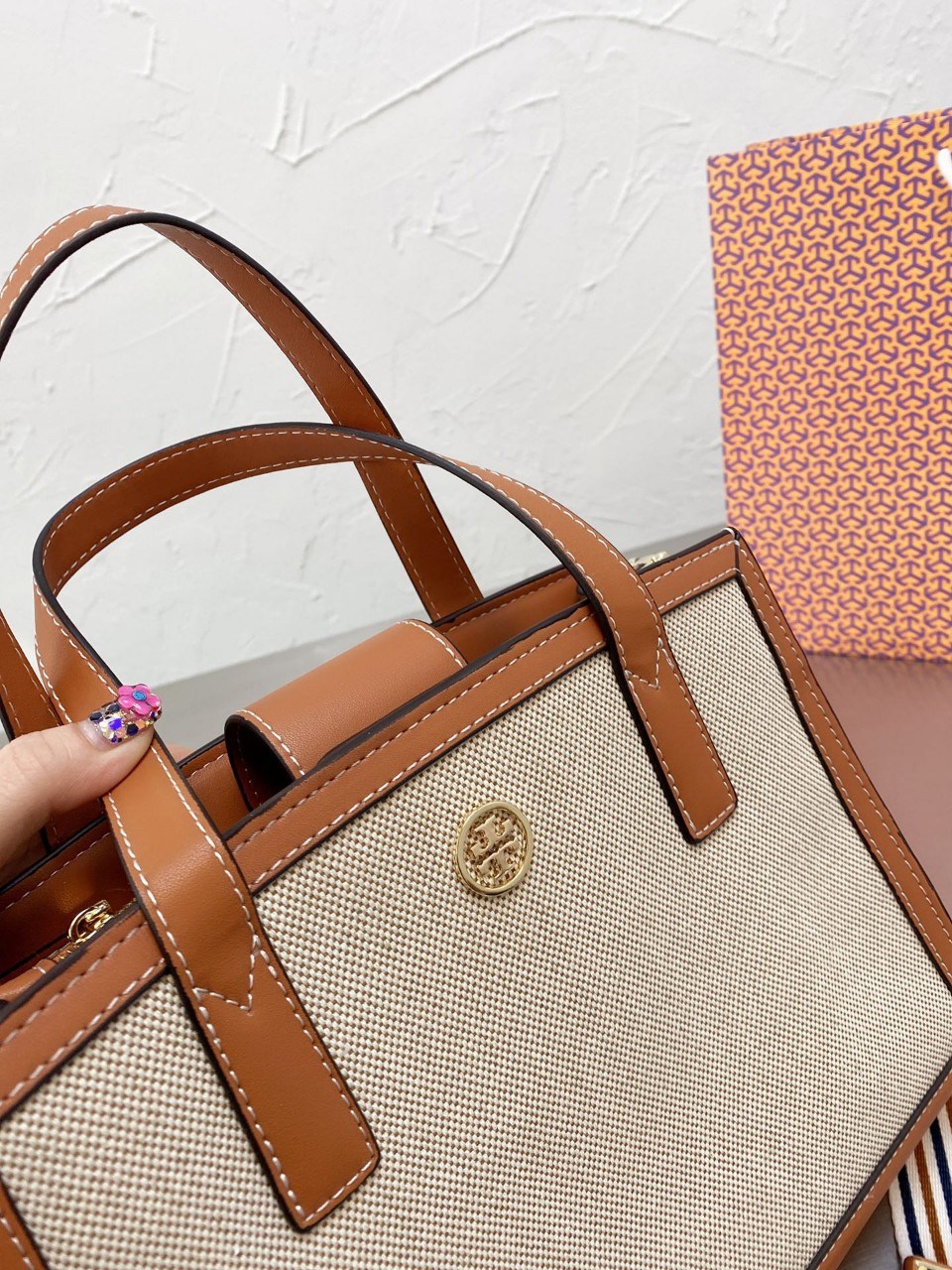 TORY BUTCH SMALL WALKER CANVAS กระเป๋าถือ สะพาย ดีไซสน์สวย เป็นเอกลักษณ์ วันดุผ้า CANVAS ด้านนอกประดับโลโก้แบรนด์ด้านหน้า ตัดด้วยหนังแท้รอบใบ ด้านในเปิดปิดด้วยหนังคาดกระดุมแม่เหล็ก แบ่งของใส่ของเป็นสองช่องใหญ่ พร้อมข่องซิปกลาง สามารถใส่ไอแพด กระเป๋าสตางค์