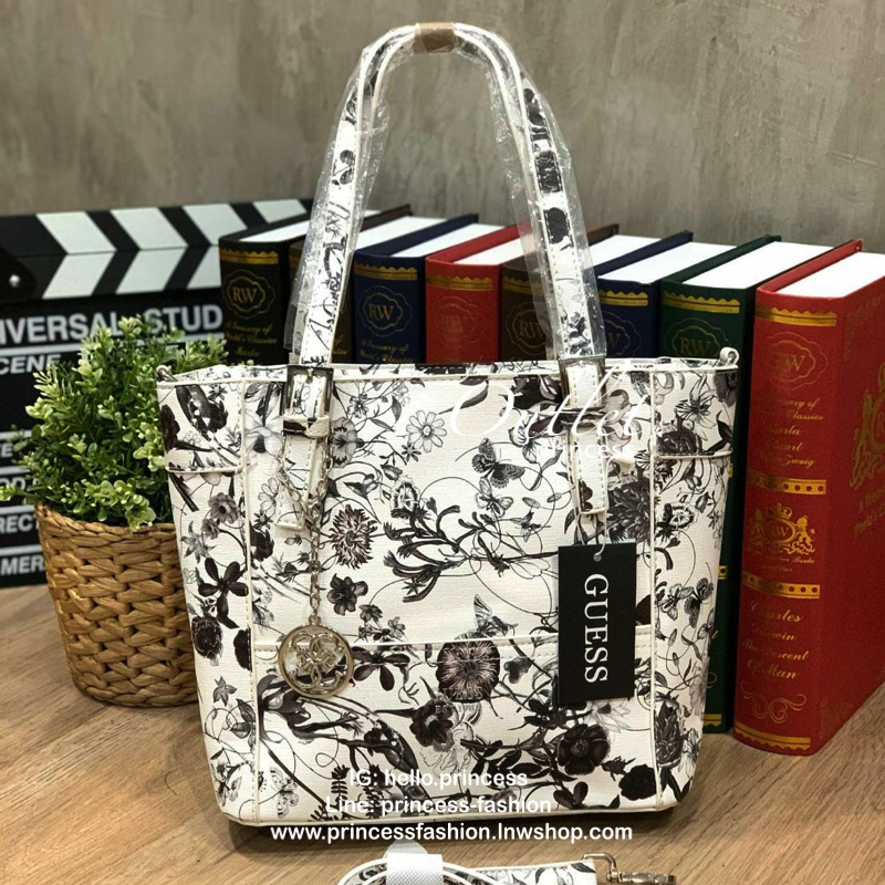 GUESS Women's Medium Floral Tote Bag กระเป๋าถือ คล้องไหล่หรือสะพาย ขนาดกลาง วัสดุหนังpu ลายดอกไม้ชนิดต่างๆรอบใบ เปิดปิดใช้งานด้วยซิปเดียวด้านบน ภายในมีกว้างใส่กระเป๋าสตาวค์ยาว มินิไอแพคได้ หูจับและสายสะพายปรับระดับได้ มาพร้อมกุญแจโลโก้guess สวยน่ารัก