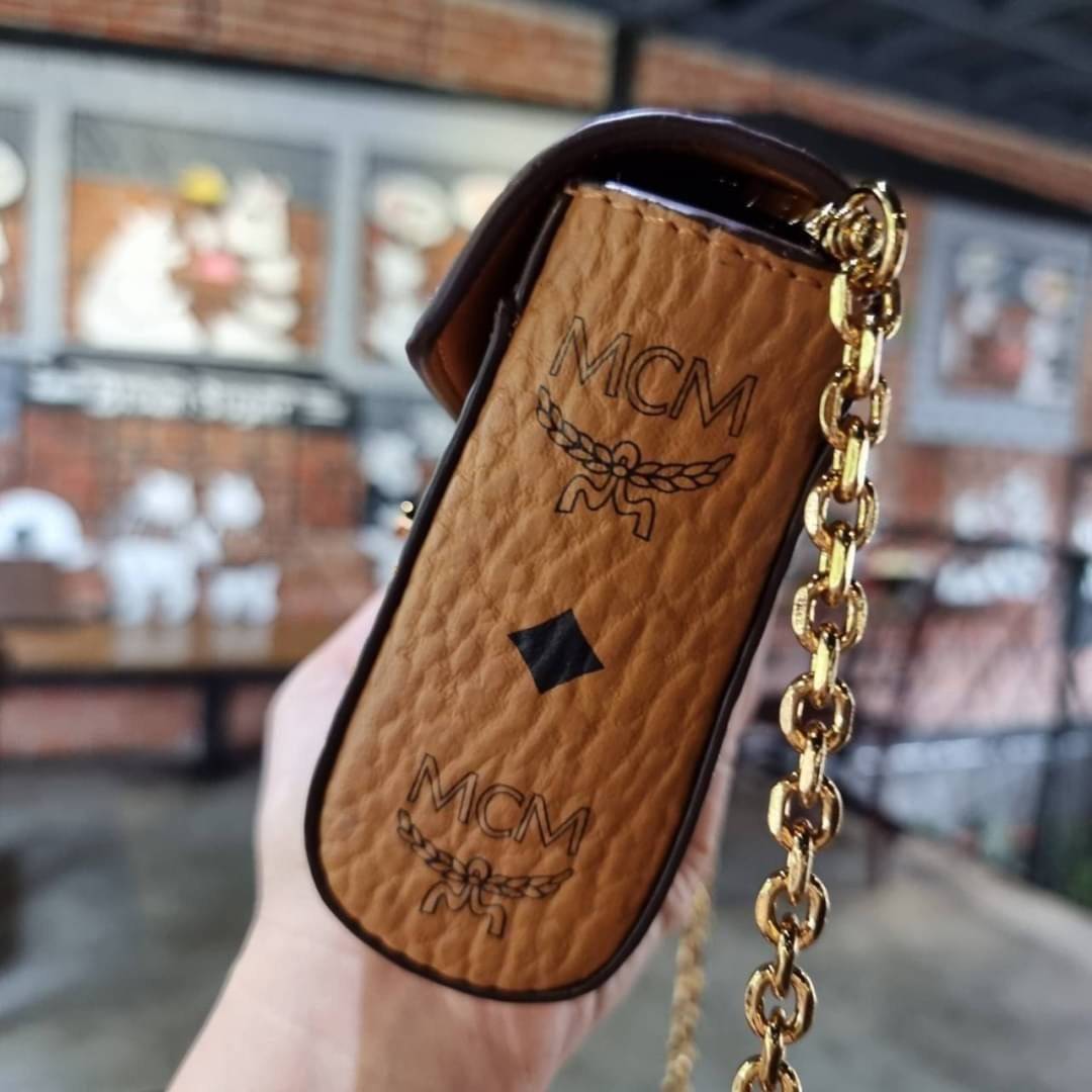 M.C.M SMALL MILLIE FLAP CROSSBODY IN VISETOS ไซส์ใหม่พกพาสะดวก!! กระเป๋าสะพายกึ่งคลัทช์ รอบนี้มาไซส์สวย สามารถใช้แทนกระเป๋าสตางค์ได้เลย ใส่โทรศัพท์มือถือได้ทุกรุ่น ใส่ของสำคัญสบายๆ มาพร้อมสายสะพายโซ่สีทองหรูหรา รูปทรงดีไซน์ร่วมสมัย ใช้งานง่ายด้วยตัวล็อค ว