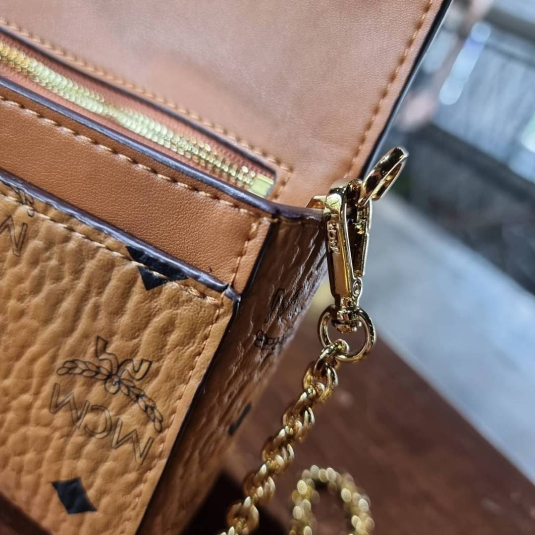 M.C.M SMALL MILLIE FLAP CROSSBODY IN VISETOS ไซส์ใหม่พกพาสะดวก!! กระเป๋าสะพายกึ่งคลัทช์ รอบนี้มาไซส์สวย สามารถใช้แทนกระเป๋าสตางค์ได้เลย ใส่โทรศัพท์มือถือได้ทุกรุ่น ใส่ของสำคัญสบายๆ มาพร้อมสายสะพายโซ่สีทองหรูหรา รูปทรงดีไซน์ร่วมสมัย ใช้งานง่ายด้วยตัวล็อค ว