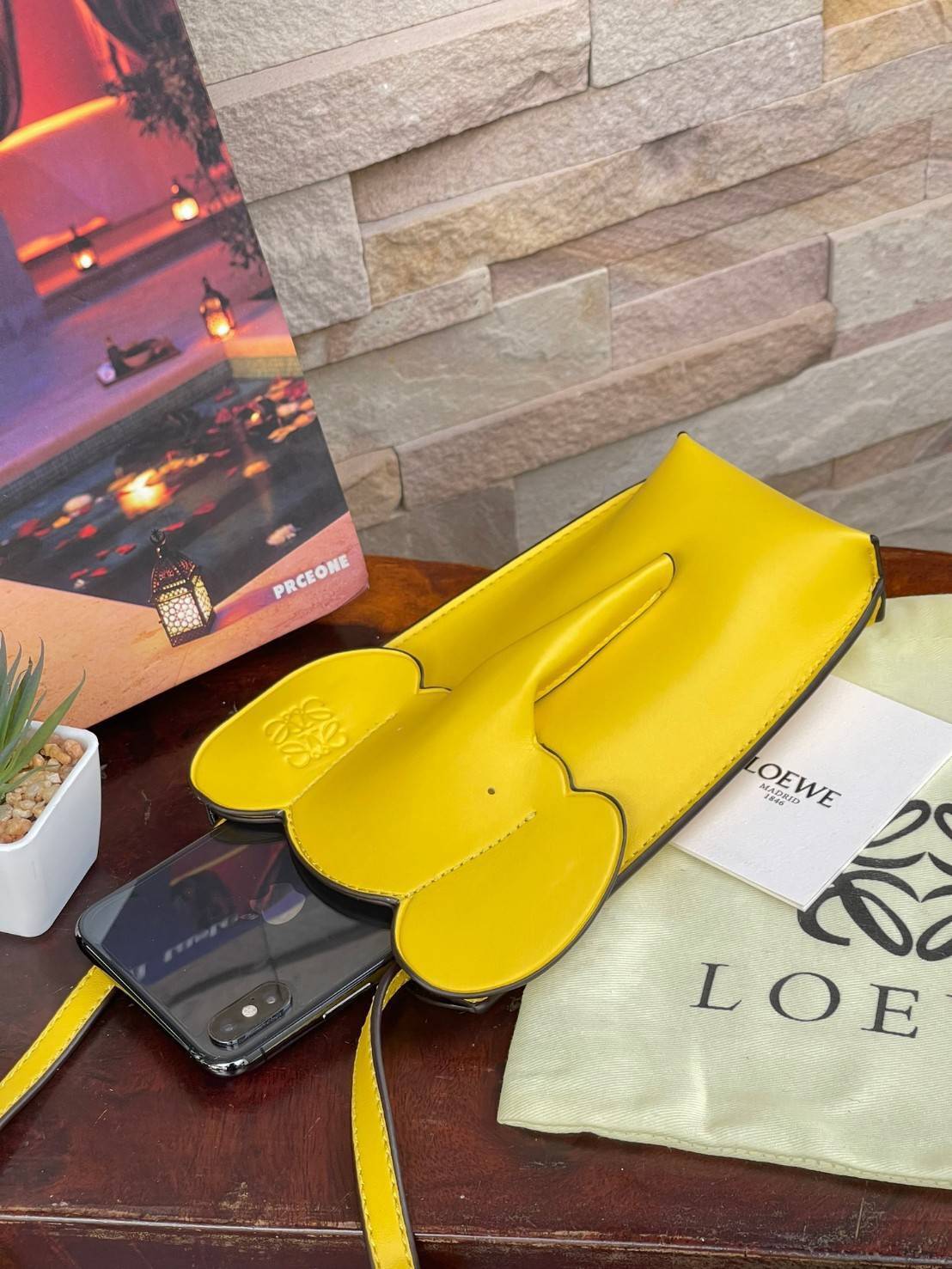 Loewe Leather Elephant Phone Holder แบรนด์หรูจากประเทศสเปนอย่าง โลเอเว่ (LOEWE) หลายๆคนคงนึกถึงกระเป๋ารูปทรงช้างขนาดเล็ก ที่เป็นเหมือนหนึ่งในซิกเนเจอร์ของแบรนด์ มีทั้งแบบสะพายข้าง แบบถือ รวมไปถึงในแบบเครื่องหนังชิ้นเล็กอย่างกระเป๋าใส่มือถือรุ่นนี้ ผลิตจาก