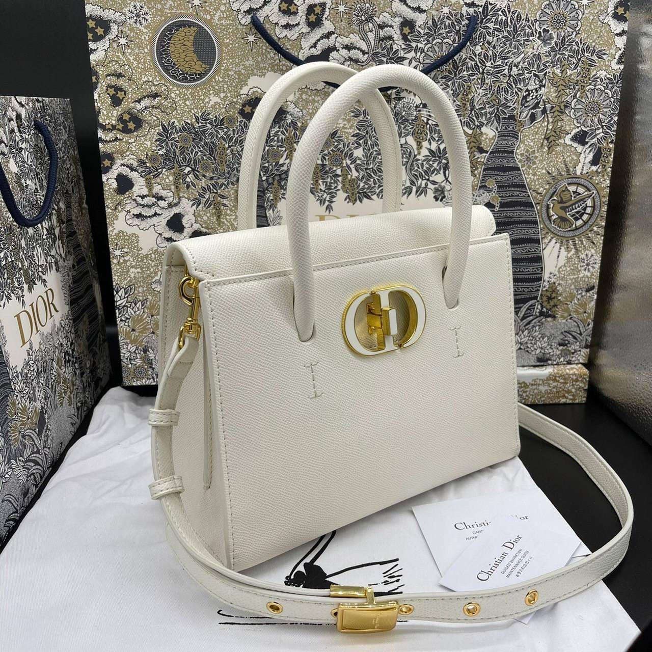 หนังแท้ DIOR Medium ST Honore Tote Collection Fall/Winter 2020-2021 มาในรูปแบบกระเป๋าทรงสี่เหลี่ยมที่ได้มาตรฐาน ทำจากหนังลูกวัว (Calfskin) ลายเกรน ซึ่งสื่อถึงความหรูหราได้อย่างลงตัว ตัวด้ามจับ มีการเย็บเข้าด้านในของกระเป๋าเพื่อเพิ่มความแข็งแรงทนทาน ด้านหน