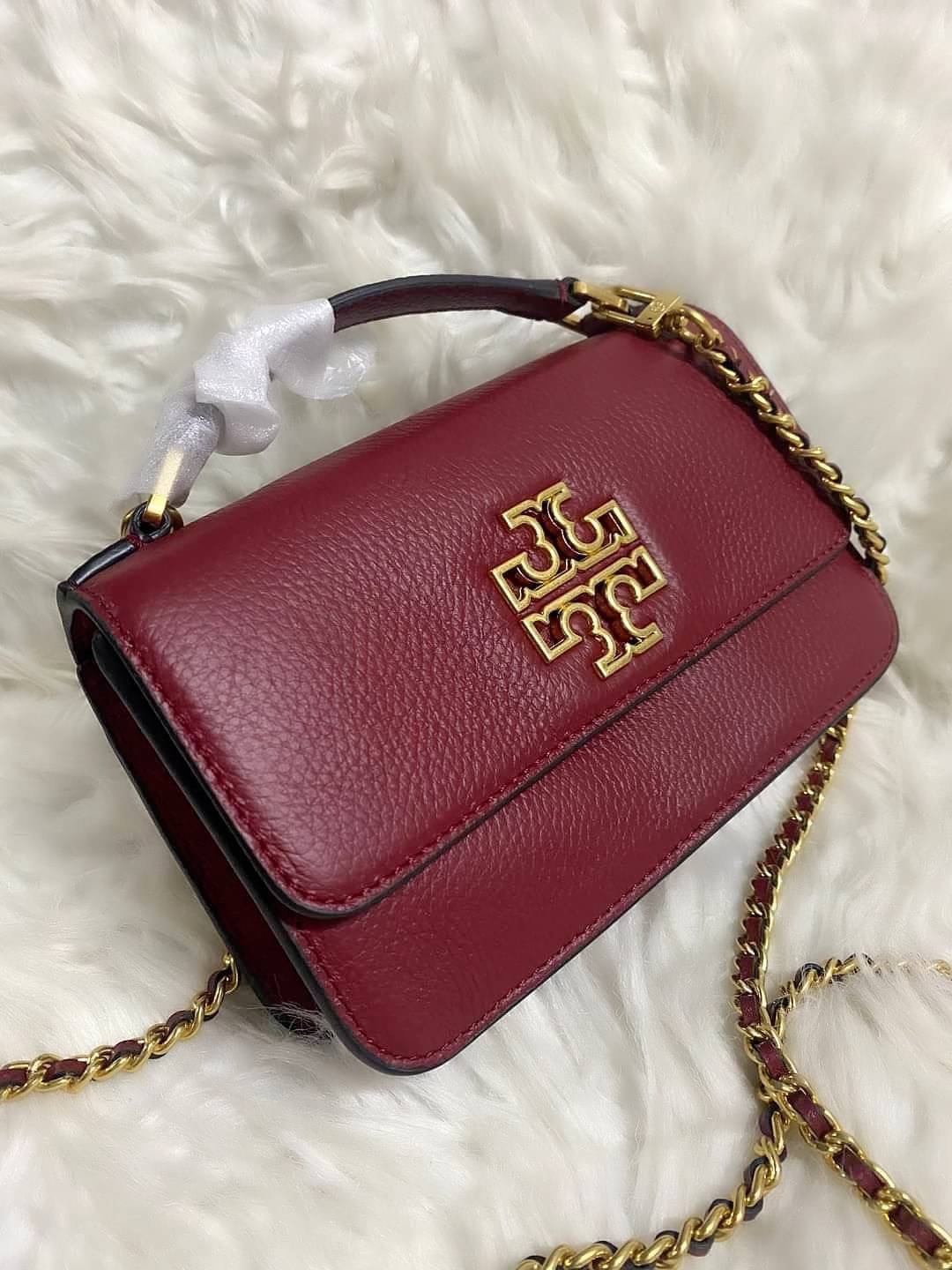 TORY BURCH BRITTEN MINI TOP HANDLE BAG พร้อมส่งที่ไทย กระเป๋าสะพาย Crossbody วัสดุหนังวัวแท้ การออกแบบเรียบง่าย ยังคงความหรูหราเอาไว้ มาพร้อมสายยาวโซ่อะไหล่ทองสลับหนัง ถอดออกได้ ตอบสนองการใช้งานได้ดี มีหูหิ้วด้านบนสามารถใช้งานได้ในหลายโอกาสค่ะ