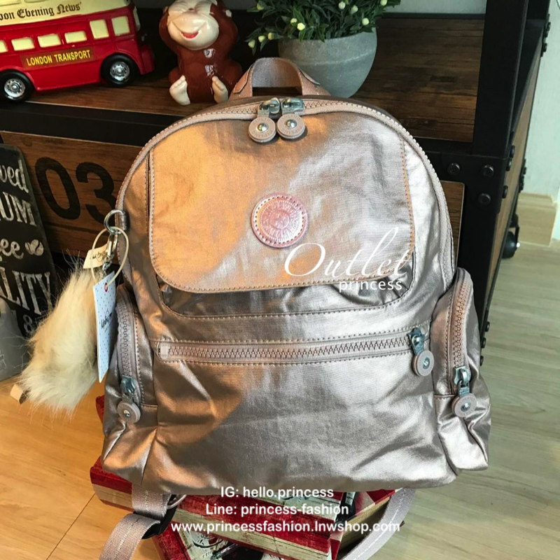 Kipling Matta Small Metallic Backpack กระเป๋าเป้ขนาดกำลังดี วัสดุไนล่อนเคลือบกันน้ำ มีน้ำหนักเบา มีช่องเก็บของหลายช่อง แบ่งเป็นช่องด้านหน้า 2 ช่องและด้านข้างอีก 2 ช่อง ช่องใหญ่ปิดเปิดด้วยซิปคู่ภายในมีช่องซิป ช่องใส่ของจุกจิกและสายห้อยพวงกุญแจ ด้านหน้าประด