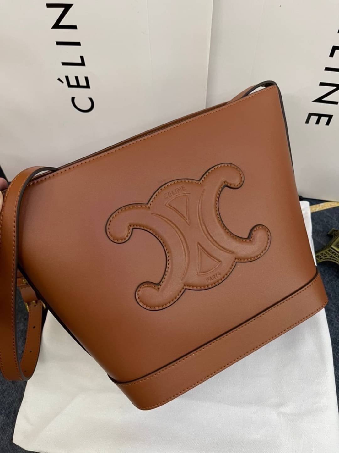 หนังแท้ CELINE SMALL BUCKET CUIR TRIOMPHE IN SMOOTH CALFSKIN / CELINE BUCKET BAG CUIR TRIOMPHE พร้อมส่งที่ไทย คอลเลคชั่นใหม่ ฮิตข้ามปี กับกระเป๋าสะพายทรงถัง ใช้งานง่ายที่สุด สายสะพายในตัว ปรับใช้ได้เลย วัสดุหนังวัว เรียบหรู ผู้ดีไปอีก โดดเด่นด้วยโลโก้เอกล