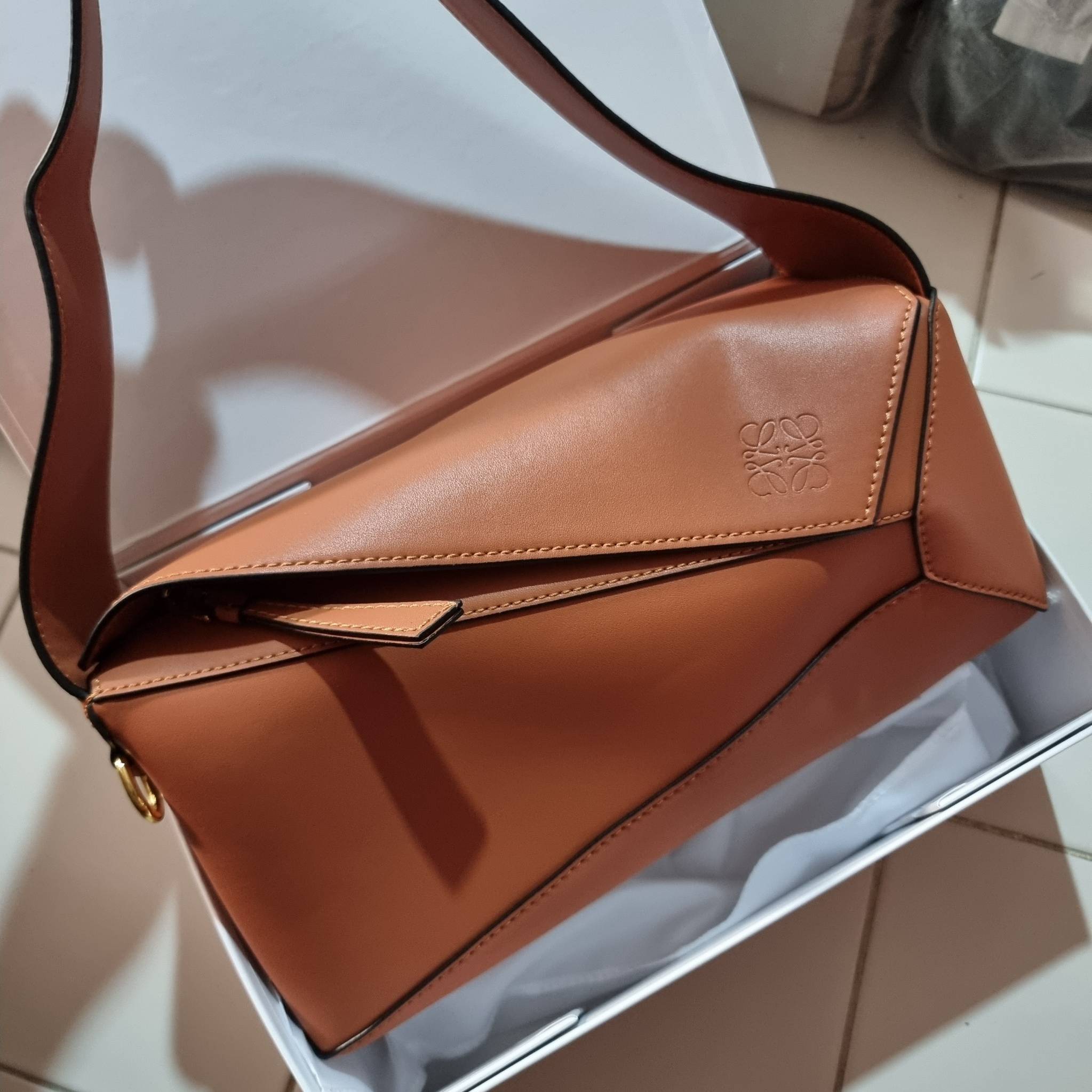 LOEWE PUZZLE HOBO BAG ใหม่ล่าสุด กับแบรนด์ที่มีดีไซน์โดดเด่นเป็นเอกลักษณ์ สวยหรูทุกรุ่นจริงๆ!! กระเป๋าสะพายโฮโบ ทรงสวย สไตล์พัซเซิลคลาสสิค วัสดุหนังวัวฟอกสี นิ่มมือ ฟินมาก!! เปิดใช้งานด้วยซิป ที่ภายในโล่งกว้าง ใส่ของสำคัญได้ครบไม่มีพลาด แบบสบายๆ มาพร้อมสา