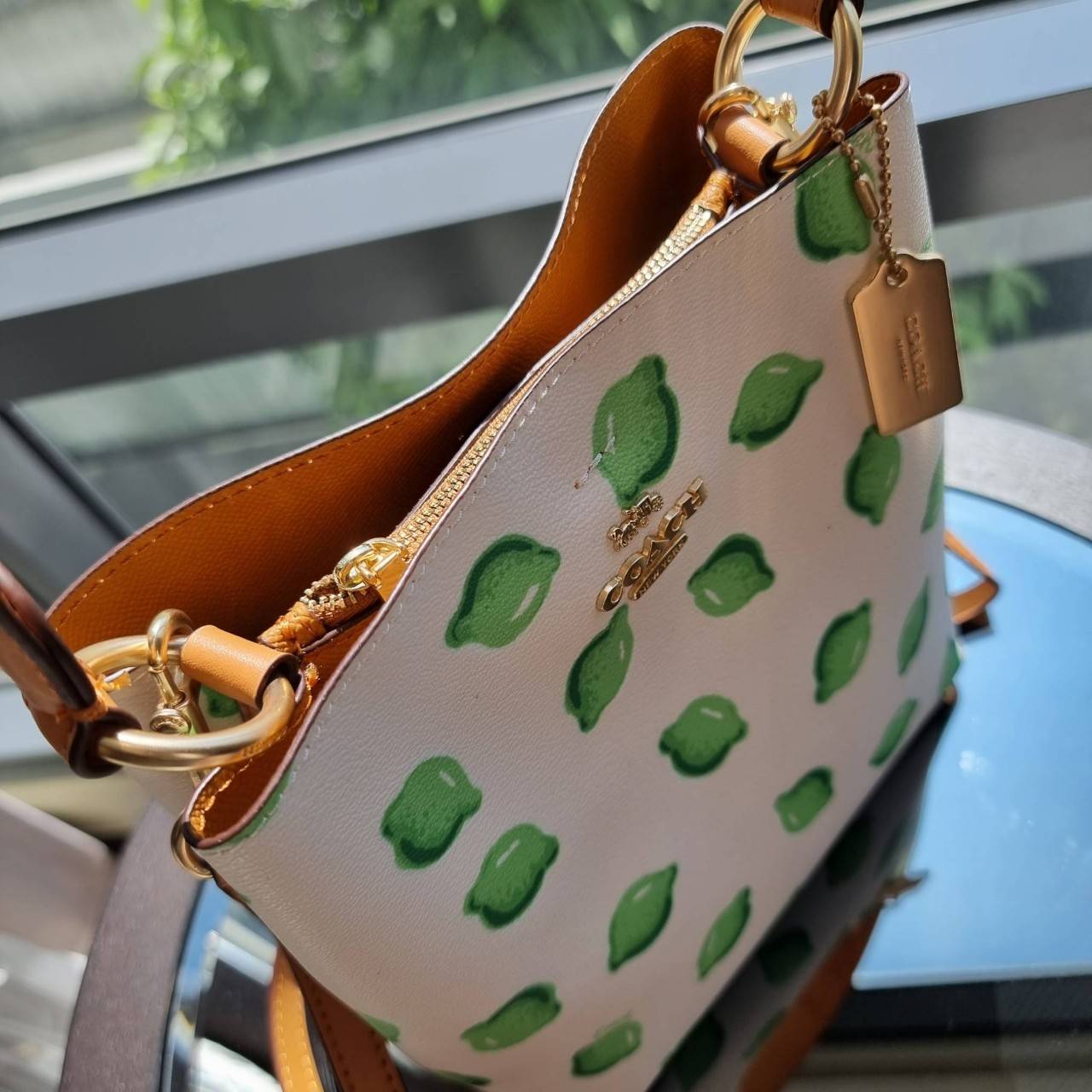 OUTTLET 】COACH 1625 SMALL TOWN BUCKET BAG WITH LIME PRINT ต้อนรับปีใหม่ด้วยความสดใส กับรุ่นยอดนิยม กระเป๋าทรงบัคเก็ตไซส์เล็ก ดีไซน์ลวดลายจี๊ดจ๊าด น่าใช้จริงจัง วัสดุหนังแคนวาสเคลือบลาย สวยคมแซ่บมากๆ เปิด-ปิดด้วยกระดุมแม่เหล็กทั้ง 2 ฝั่ง ภายในเป็นช่องโล่ง 