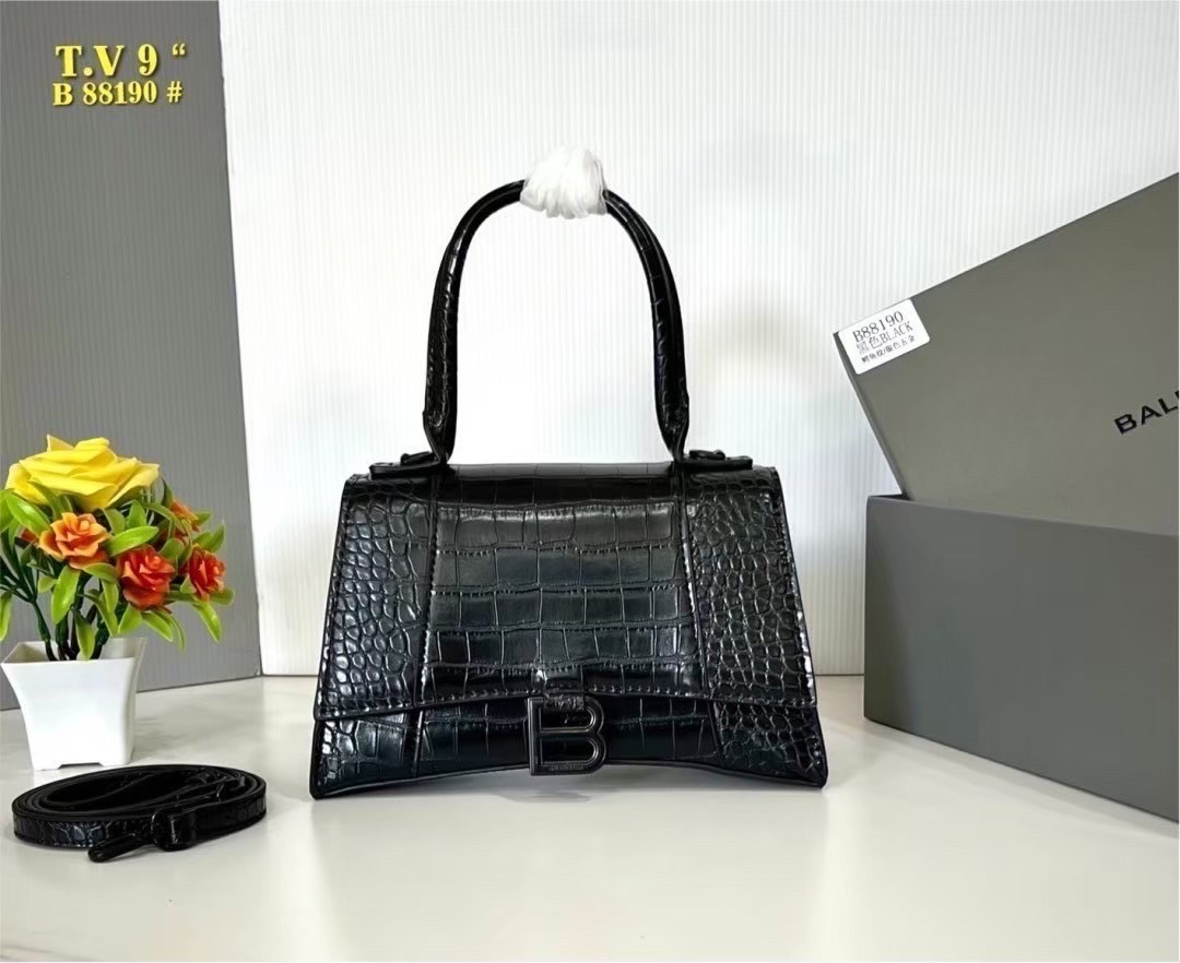 BALENCIAGA Hourglass top-handle tote bag กระเป๋าสะพายแบรนด์หรูซิกเนเจอร์ ที่มาพร้อมดีไซน์โดดเด่น มีความโฉบเฉี่ยว โค้งมนเหมือนพระจันทร์เสี้ยว เพิ่มความสวยสะดุดตาด้วยการตกแต่งอักษร B เมทัลลิก