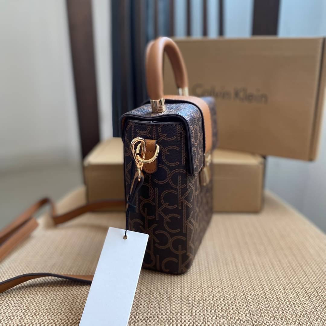 CALVIN KLEIN JEANS crossbody bag กระเป๋าถือหรือสะพาย ลายซิกเนเจอร์แบรนด์ทั้งใบ มีหูจับสำหรับถือ เปิด-ปิดกระเป๋าด้วยกระดุมแม่เหล็ก ด้านในโล่งกว้างมีช่องเล็กและช่องซิปสำหรับใส่ของจุกจิก ซับในลายแบรนด์อย่างดี มาพร้อมสายสะพายยาวปรับระดับได้ สามารถใช้ได้หลากหล