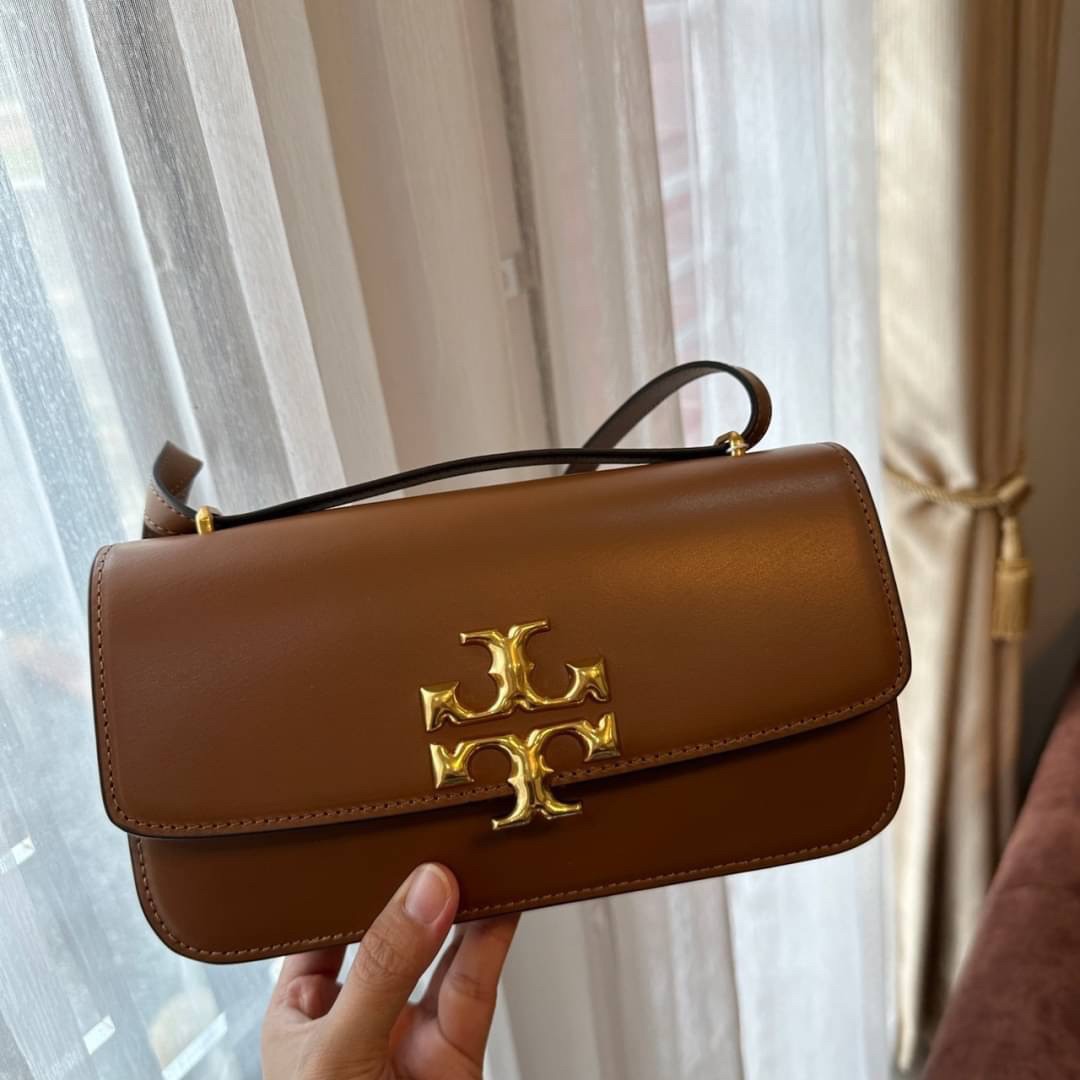 TORY BURCH ELEANOR SMALL LONG CONVERTIBLE SHOULDER กระเป๋าสะพายทรงยาว E/W Eleanor Convertible สูดหรู ดูแพง หนังแท้ เรียบสวยหรู โดดเด่นด้วยป้ายโลโก้สีทอง ลาย Double T อันเป็นเอกลักษณ์ ภายในช่องโล่งกว้างสามารถใส่โทรศัพท์ได้ทุกรุ่น สามารถใส่กระเป๋าสตางค์ใบยา