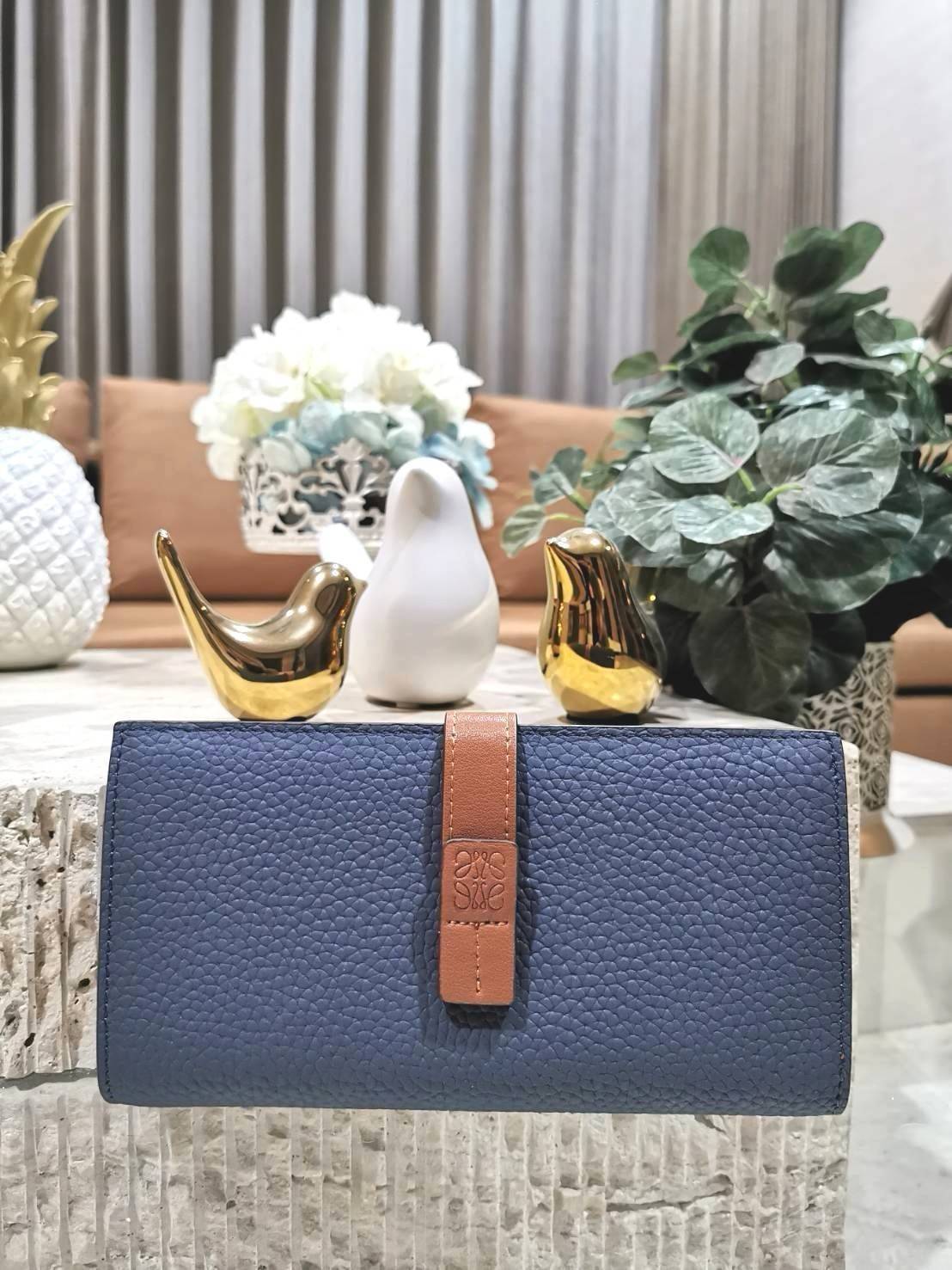 LOEWE LONG WALLET BAG วัสดุหนังแท้เทคเจอร์สวยอยู่ทรงปั้มโลโก้แบรนด์ด้านหน้าเปิดปิดด้วยกระดุม ภายในมีช่องใส่ธนบัตรหลายช่อง ช่องหลักสามารถใส่มือถือได้ มีช่องซิปใส่เหรียญ ช่องใส่ธนบัตรใส่แบงก์พันได้ สวยน่าใช้ พร้อมส่งที่ไทยสุดคุ้มห้ามพลาด!