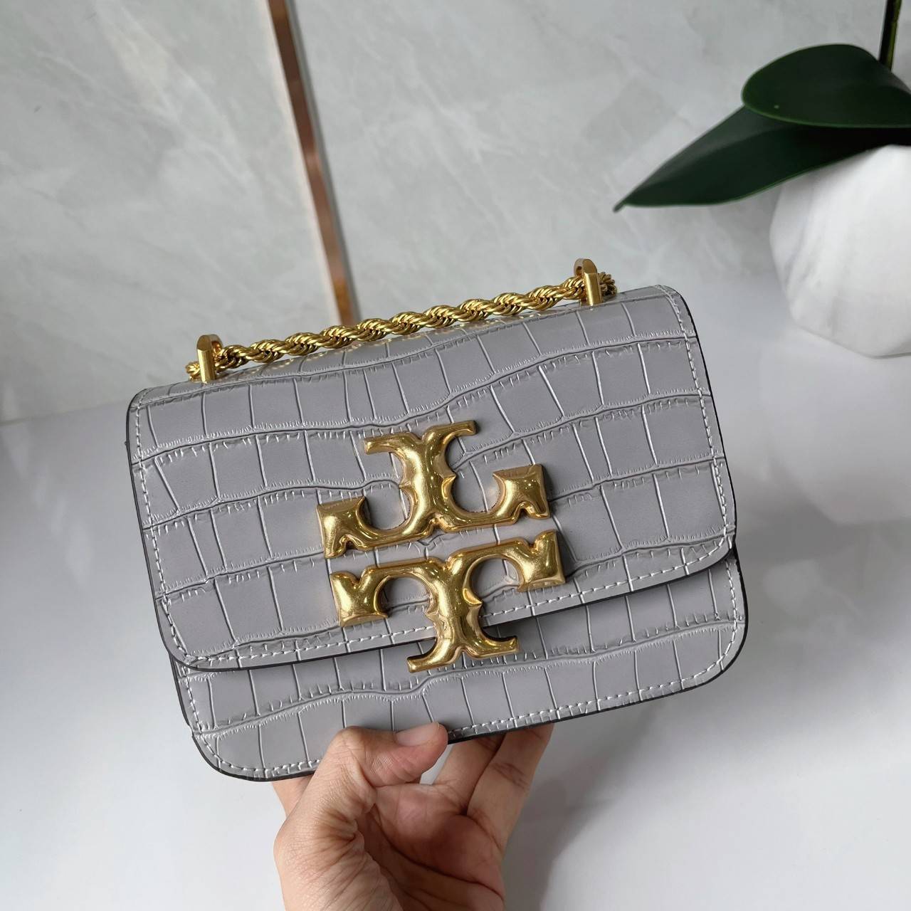 6 สี Tory Burch Croc Eleanor Small Bag / TORY BURCH ELEANOR CROC EMBOSSED LEATHER กระเป๋าสะพายหนังพิมพ์ลายจระเข้ ดีไซน์หรูหรา โด่นเด่นด้วยโลโก้แบรนด์อะไหล่ด้านหน้า และสายสะพายโลหะสีทอง