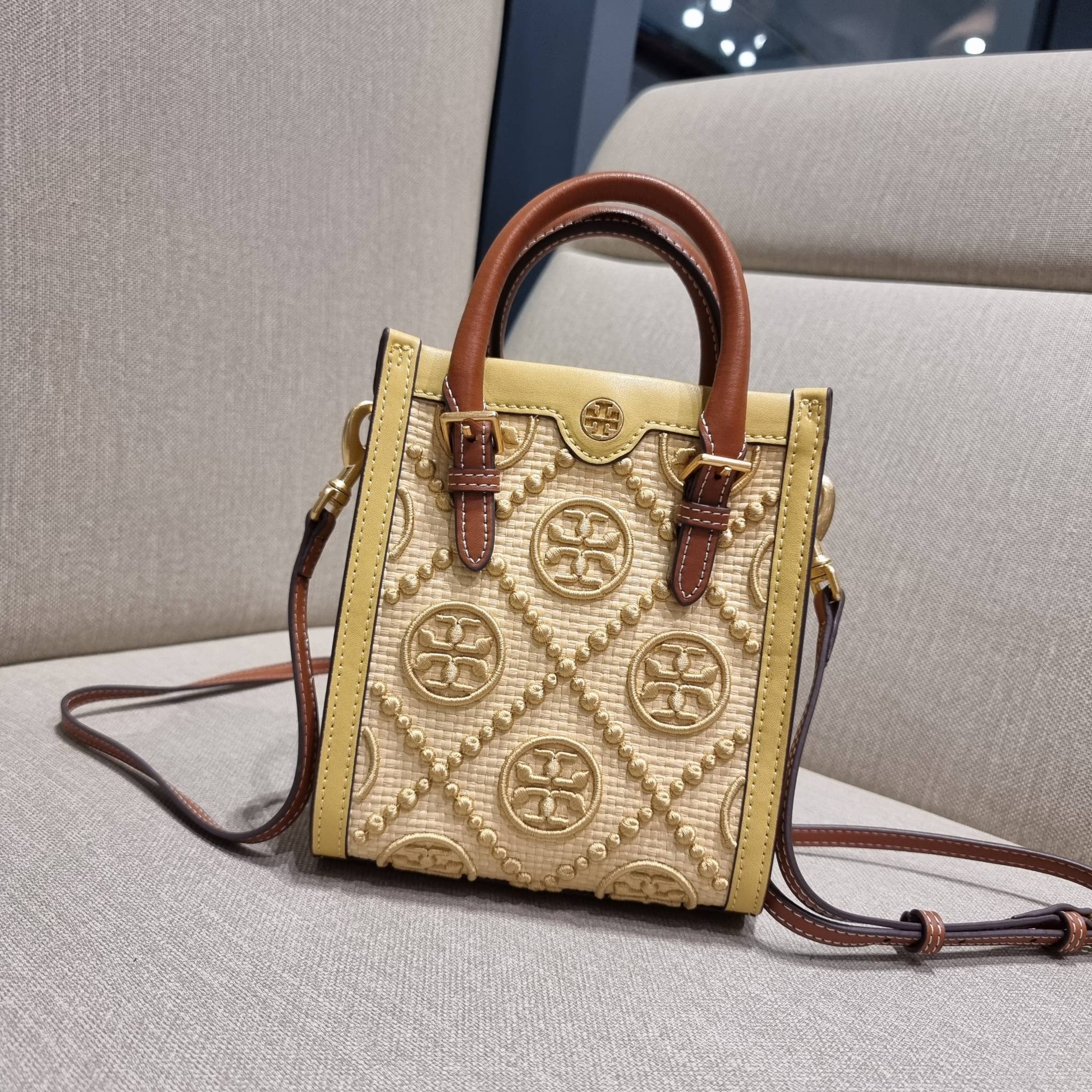 TORY BURCH T MONOGRAM STRAW MINI TOTE สวยสุด ดูแพงสุด!! ต้องยกให้เลย กับไอเท็มนี้ กระเป๋าสะพายทรงโท้ท ไซส์มินิ มีลูกเล่นที่ดีเทลเยอะมาก ด้วยงานฝีมือปักสานด้วยวัสดุจากกธรรมชาติ ถักทอเป็นลายเส้นขึ้นลายนูน ตัดขอบด้วยหนังแท้ และยังโดดเด่นด้วยหูจับในตัวโทนสีอุ