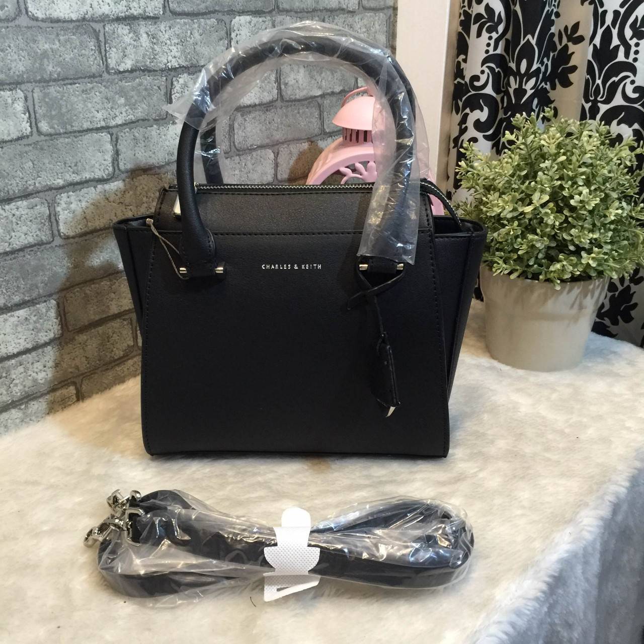 CHARLES & KEITH MINI CITY BAG กระเป๋าถือหรือสะพาย ขนาดกะทัดรัด กำลังดี หนังpu เรียบ อยู่ทรงแข็ง เปิด-ปิดด้วยซิป ด้านหน้าห้อยประดับอะไหล่ปั๊มโลโก้ ดูเรียบหรู ภายในมีช่องซิปเล็ก 1 ช่อง มาพร้อมสายสะพายยาวปรับได้ ฐานมีหมุดรองฐานกันรอยสี่มุม สะพายสบายๆไปเที่ยว