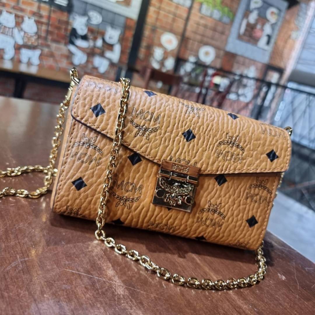 M.C.M SMALL MILLIE FLAP CROSSBODY IN VISETOS ไซส์ใหม่พกพาสะดวก!! กระเป๋าสะพายกึ่งคลัทช์ รอบนี้มาไซส์สวย สามารถใช้แทนกระเป๋าสตางค์ได้เลย ใส่โทรศัพท์มือถือได้ทุกรุ่น ใส่ของสำคัญสบายๆ มาพร้อมสายสะพายโซ่สีทองหรูหรา รูปทรงดีไซน์ร่วมสมัย ใช้งานง่ายด้วยตัวล็อค ว