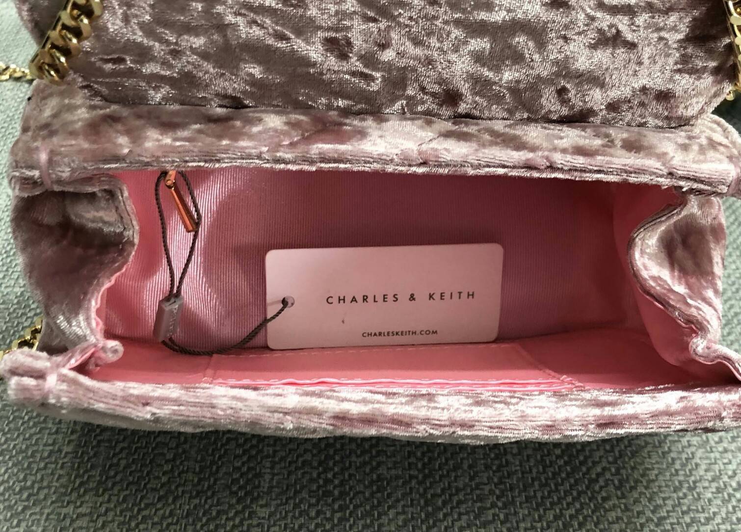 CHARLES & KEITH TASSEL DETAIL SHOULDER BAG กระเป๋าสะพายข้าง ทรงน่ารัก ด้านหน้ามีพู่ห้อย เปิดปิดกระเป๋าแบบแม่เหล็ก ด้านในโล่ง มีช่องซิป 1 ช่อง และช่องใส่บัตรได้ 3 ช่องค่ะ สายสะพายโซ่สีทองหรูหราค่ะ