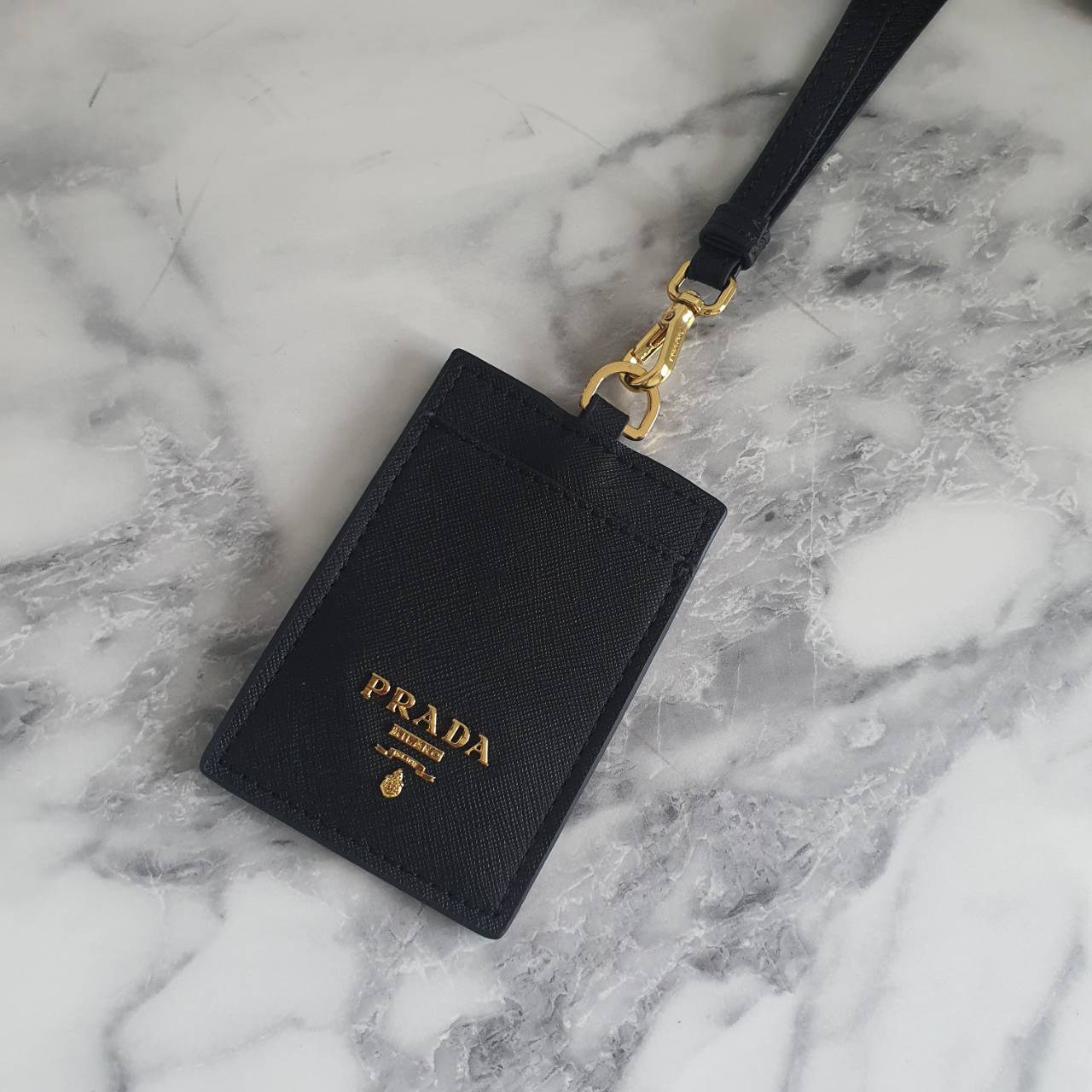 สิ้นสุดการรอคอย!! พร้อมส่งที่ไทยแล้วค่ะ สายคล้องบัตรสุดคลาสสิค จากงานพรีเมี่ยมกิ้ฟท์แบรนด์ดังอย่าง PRADA วัสดุหนังพรีเมี่ยม SAFFIANO อะไหล่ทอง ปั้มแบรนด์ ด้านหน้ามีช่องใส่บัตร1ใบ ประกับโลโก้PRADA และด้านหลังใส่บัตรได้อีกหนึ่งใบ(แบบใส) สำหรับโชว์บัตร ไอเท็