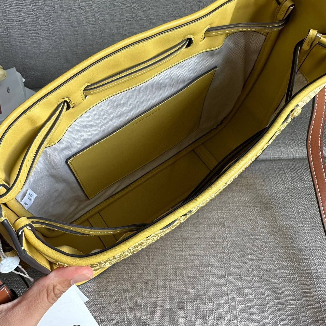 TORY BURCH T Monogram Straw Bell Bag กระเป๋าสะพายข้างรุ่นคลาสสิกที่ได้แรงบันดาลใจจากการควิลท์แบบดั้งเดิมของเพนซิลเวเนีย คอลเลกชันบ่งบอกถึงความมีสไตล์เหนือกาลเวลา รูปทรงเรียวโดดเด่น ปักทอลายแบรนด์อย่างสวยงาม เปิด ปิดด้วยเชือกรูด ด้านในช่องโล่งกว้าง ซับในผ้