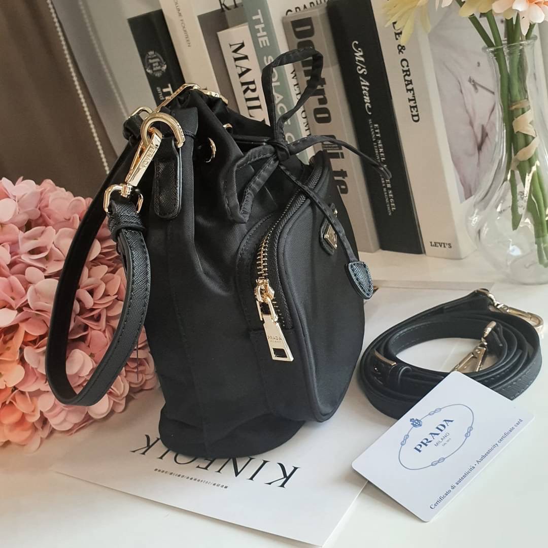 Size MINI : พร้อมส่งรุ่นขายดี!!! PRADA DRAWSTRING BAG WITH STRAP VIP GIFT WITH PURCHASE พรีเมี่ยมกิ๊ฟจากต่างประเทศรุ่น Limited วัสดุ Nylon & Polyester 100% เนื้อหนา ด้านหน้าประดับโลโก้ เปิดปิดแบบ Drawstring มาพร้อมสายสะพายให้ถึง2แบบทั้งสายสั้นและสายยาวปรั