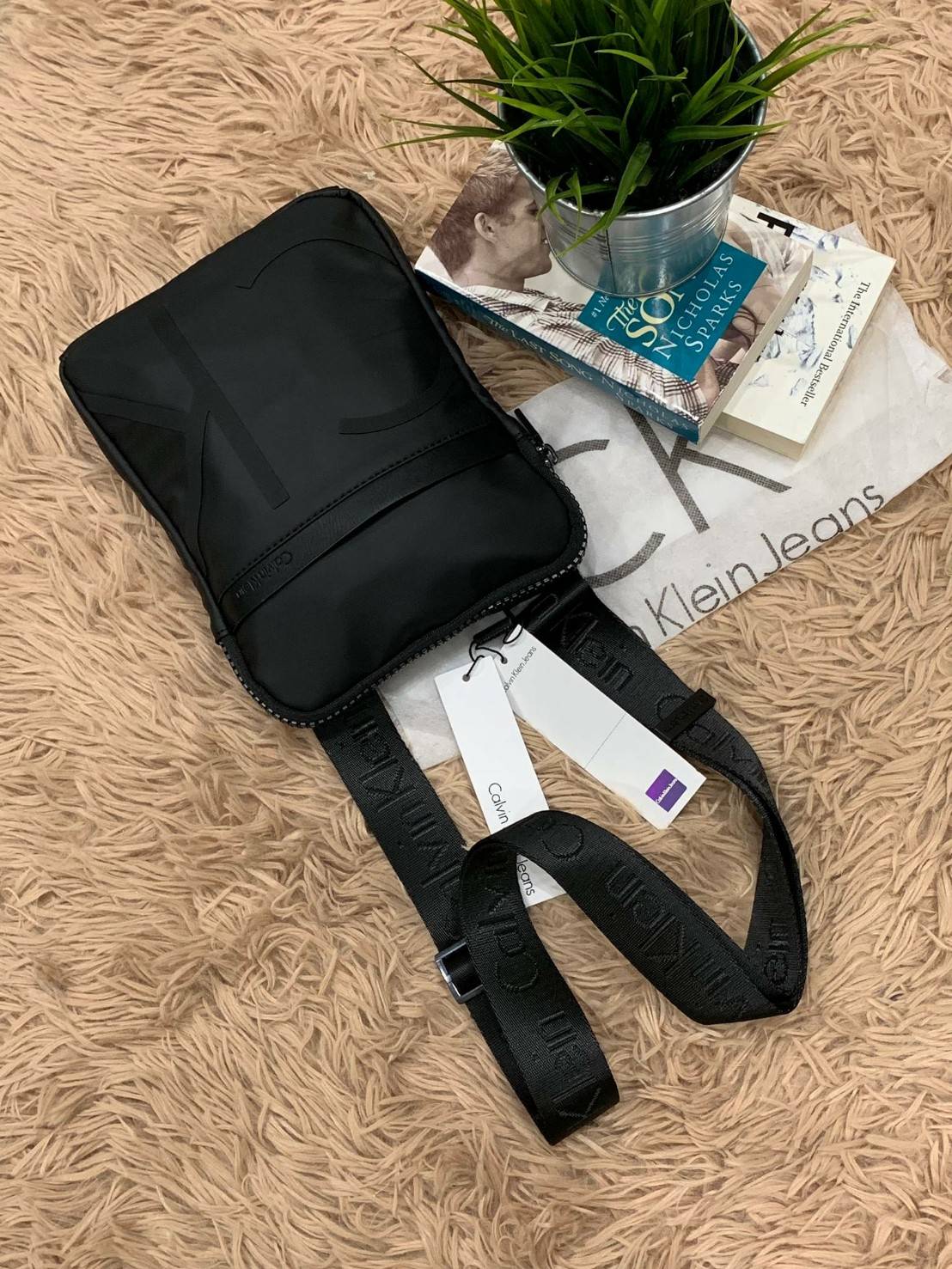 Cavin Klein Crossbody Bag กระเป๋าสะพายข้าง วัสดุหนังโพลีเอสเตอร์ น้ำหนักเบา สายสะพายปั้กโลโก้ ปรับความยาวได้ฟรีไซส์ ด้านหน้ามี1ช่องซิปใส่ของได้ หัวซิปปั้มโลโก้ทุกจุด เปิดปิดด้วยซิปเดียวด้านบน ด้านหน้ามีโลโก้เป็นอักษรย่อสวยงาม ขนาดกระเป๋าใส่มินิไอแพคกระเป๋