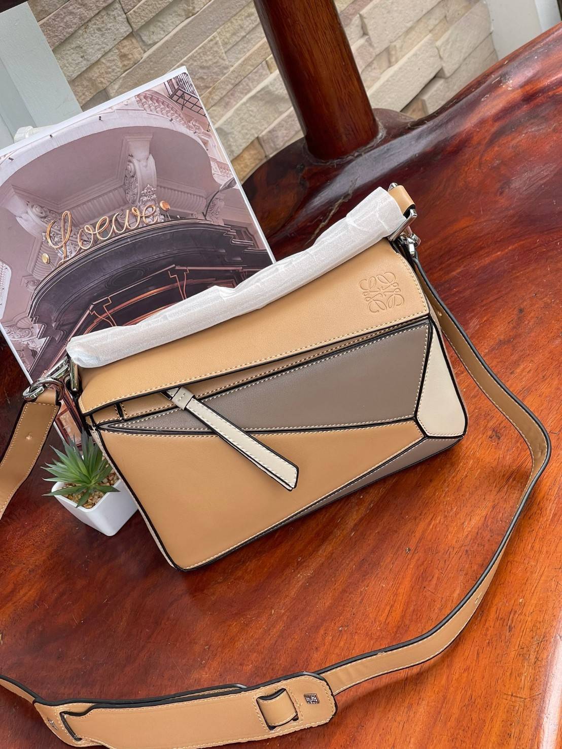 Loewe Puzzle Bag In Classic กระเป๋าทรง Puzzle นี้ออกแบบโดย Jonathan Anderson โดยได้รับแรงบันดาลใจในการออกแบบมาจากรูปทรงของลูกรักบี้ ดังนั้น จึงจะเห็นได้ว่าการตัดเย็บและรูปทรงของกระเป๋านั้นคล้ายคลึงกับลูกรักบี้ รูปทรงดูมินิมอลไม่ทิ้งคอนเซ็ปต์ของแบรนด์ สามา