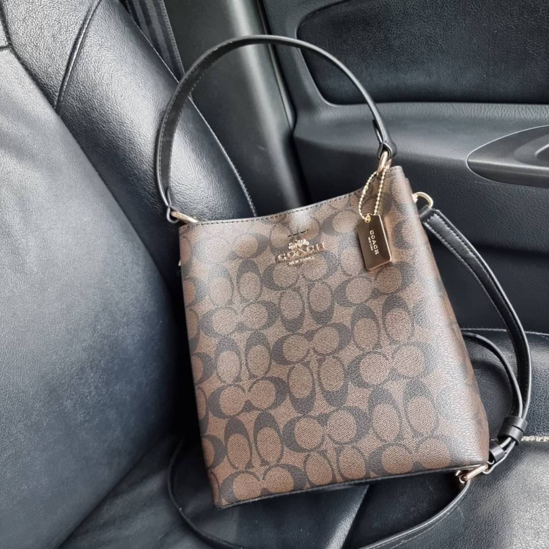 COACH 2312 SMALL TOWN BUCKET BAG IN SIGNATURE CANVAS รุ่นยอดนิยมใบเล็กมาครบสีแล้วจ้า กระเป๋าทรงบัคเก็ต สีผู้ดี๊ผู้ดี ตัวกระเป๋าดีไซน์คลาสสิคลายซี ดูโดดเด่น วัสดุหนังแคนวาสเคลือบลาย สวยคมทุกมุมจริงๆ!! เปิด-ปิดด้วยกระดุมแม่เหล็กทั้ง 2 ฝั่ง ภายในเป็นช่องโล่ง