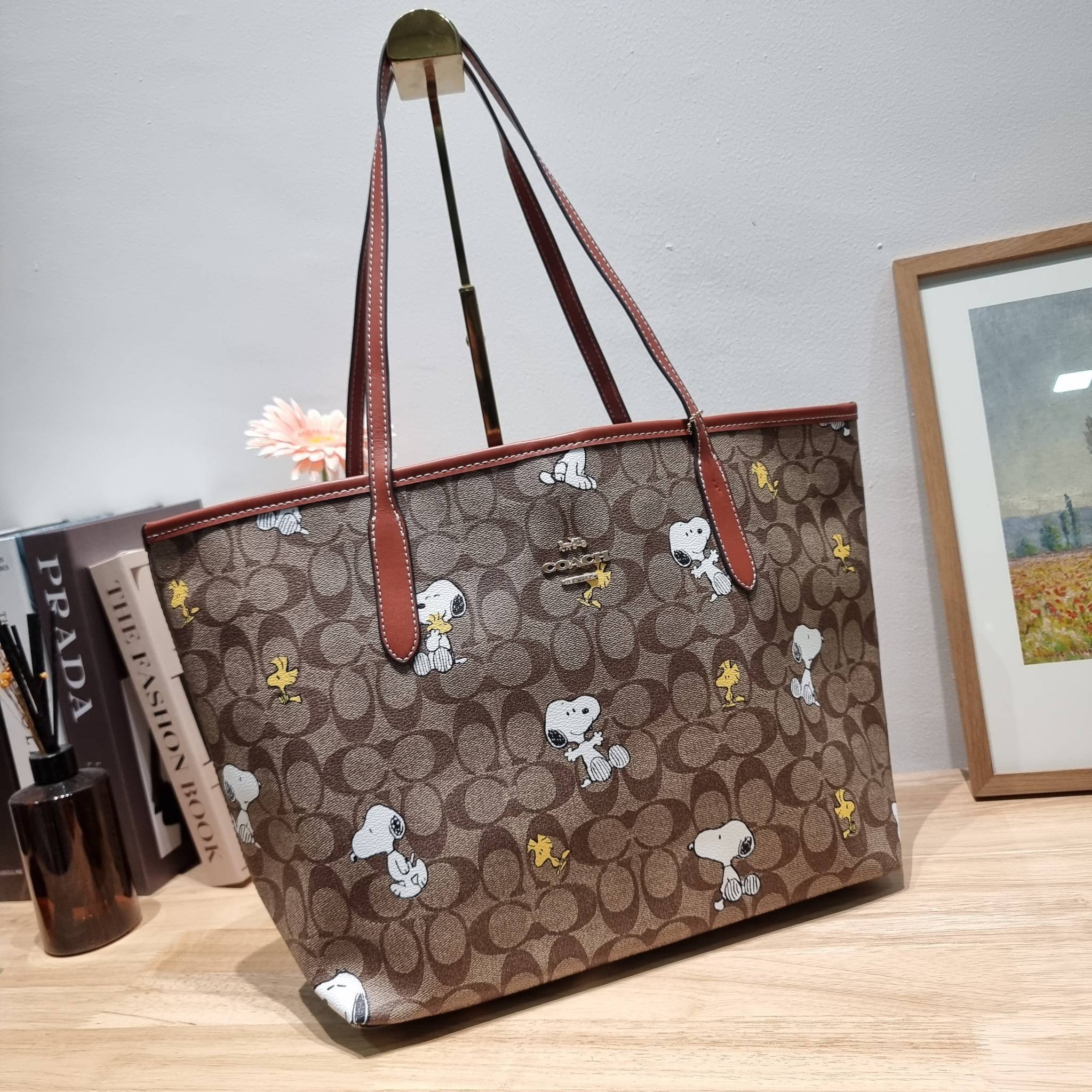 Coach X Peanuts City Tote In Signature Canvas With Snoopy Woodstock Print CF166 คอลเลคชั่นใหม่ น่ารักเกินต้าน กับกระเป๋าทรงโท้ทไซส์ใหญ่ ดีไซน์ลวดลายการ์ตูนยอดฮิต ที่ใครๆก็ต้องรู้จัก พิมพ์คมชัดลงบนหนังแคนวาส รูปทรงสวย ปากกระเป๋ามีกระดุมแม่เหล็กปิดกันของหล่