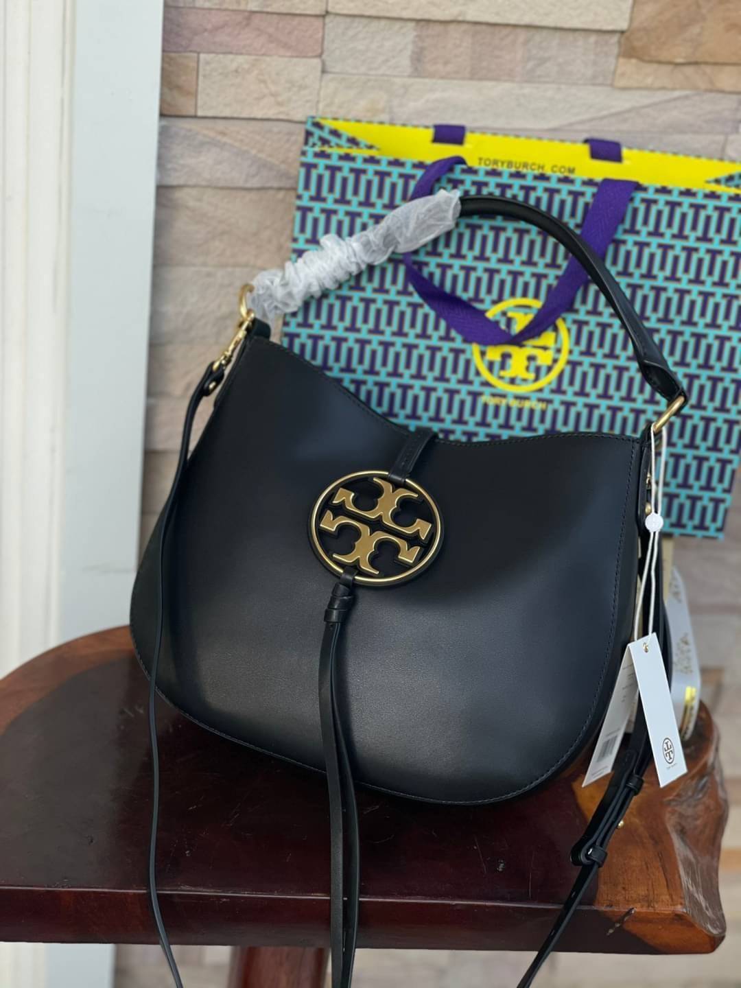 Tory burch miller metal-logo mini hobo bag มีกลิ่นอายสุดคลาสสิก ได้รับแรงบันดาลใจมาจากการขี่ม้า จึงได้ดีไซน์กระเป๋าออกมาในรูปแบบอานหลังม้าสุดเก๋ที่สามารถนำไปมิกซ์แอนด์แมทช์กับสไตล์การแต่งตัวได้หลายชนิด ไม่ว่าจะเป็นกับเดรสทรงยาวหรือกางเกงยีนแสนเท่ตัวโปรดขอ