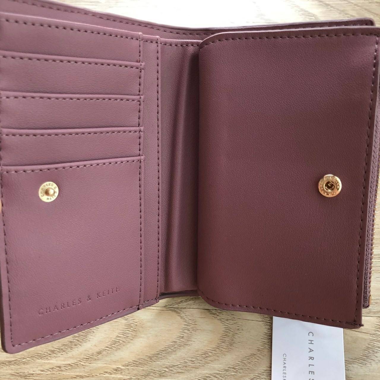 Charles & Keith Classic Snap-Button Wallet กระเป๋าสตางค์ใบสั้นพับ 2 ตอน ด้านหน้ามีโลโก้แบรนด์ เปิด - ปิดด้วยกระดุม ภายในมีช่องใส่ธนบัตร ช่องใส่บัตร และช่องซิปใส่เหรียญ
