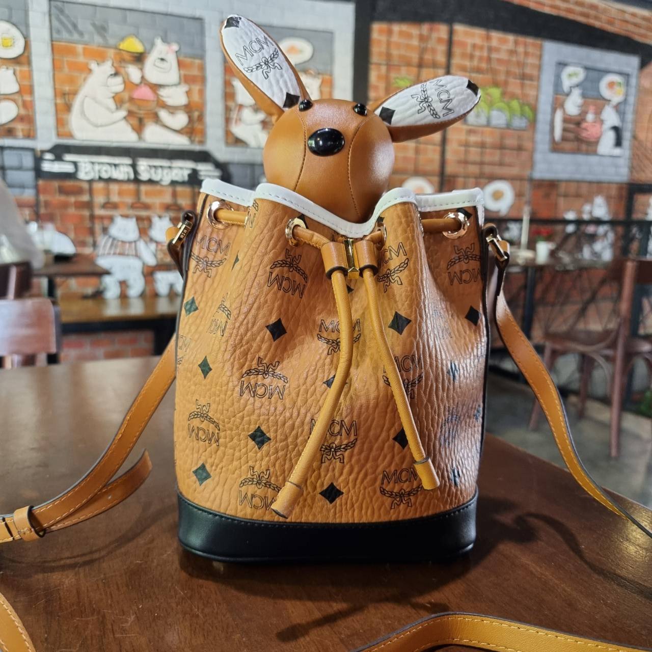 M.C.M ZOO RABBIT DRAWSTRING BAG IN VISETOS LEATHER MIX คอลเลคชั่นซูมาใหม่ ฮิตหนักมากที่เกาหลีและญี่ปุ่น ไอเท็มสุดคิ้วท์ น้องกระะต่ายโดดเด่น กระเป๋าสะพายทรง bucket ไซส์เล็กขนาดน่ารักน่าใช้ แฟชั่นสไตล์มากใบนี้ ดีไซน์น้องกระต่ายแอบในกระเป๋า และสามารถนำออกมาห