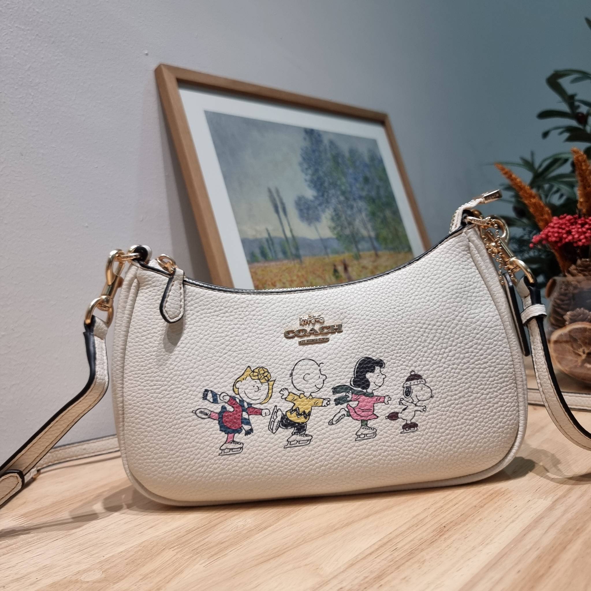 Coach X Peanuts Teri Shoulder Bag With Snoopy And Friends Motif CE861 คอลเลคชั่นสุดคิ้วท์ ไม่ให้ช้อปยังไงไหว!! กับกระเป๋าสะพายไหล่กึ่งทรงพอช พร้อมเสิร์ฟความสวยถึงบ้านไปเลยก่อนใคร แบบไม่ต้องพรีฯ ด้วยดีไซน์ลวดลายกาน์ตูนยอดฮิต มาพร้อมสายสะพาย 2 เส้น