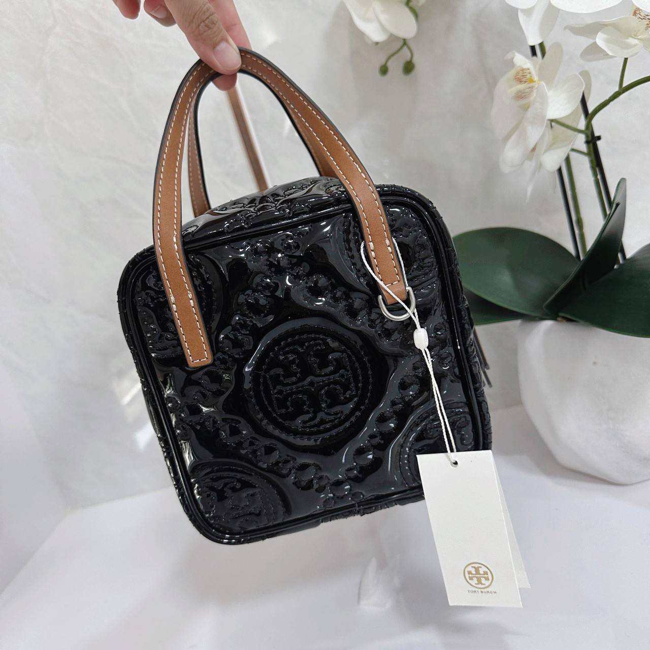Tory Burch T Monogram Embroidered Patent Cube คอลเลคชั่นใหม่ รุ่นลิมิเต็ดรูปทรงใหม่ T Monogram สุดcube วัสดุหนังแท้ เปิด-ปิดด้วยซิป ภายในกว้าง มีช่องแยก 1 ช่อง สามารถใส่โทรศัพท์มือถือได้ทุกรุ่น สามารถถือหิ้วหรือสะพายได้ สายสามารถถอดและปรับระดับได้คะ