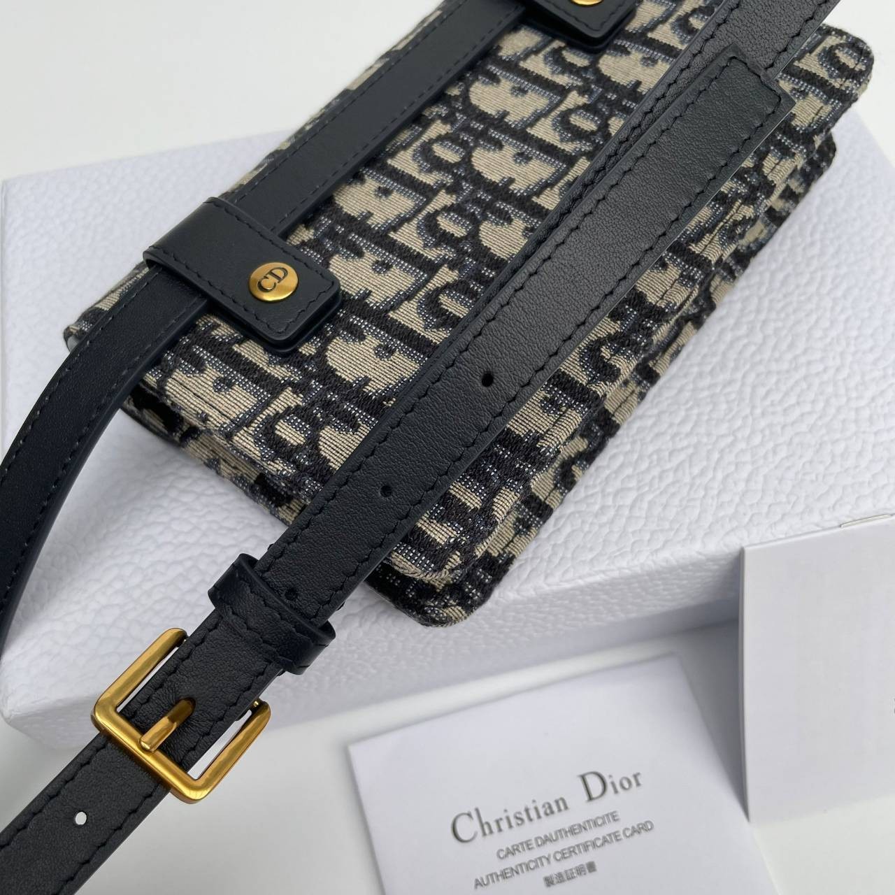 หนังแท้ DIOR SADDLE BELT POUCH Blue Dior Oblique Jacquard กระเป๋าคาดคาอก/คาดเอว เป็นทางเลือกที่ทันสมัยสำหรับกระเป๋าแบบคลาสสิก ตัดเย็บจากผ้าแจ็คการ์ด Dior Oblique โทนสี Navy Blue เข็มขัดถอดออกได้จะช่วยเสริมลุคให้ทุกชุด กระเป๋าคาดเอวจะสะพายไหล่ สะพายข้าง หร