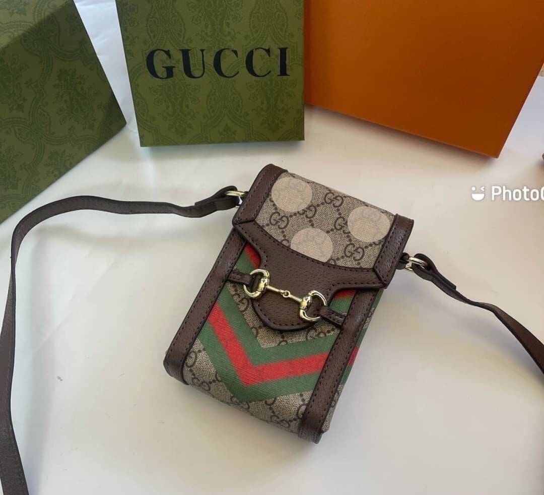 VIP 】GG CANVAS AND LEATHER CROSS-BODY PHONE BAG พร้อมส่งที่ไทย Brown canvas Brown Ophidia GG Supreme mini bag from GUCCI featuring an adjustable shoulder strap, a foldover top, a GG Supreme pattern, a Web stripe to the front and a gold-tone Double G plaqu