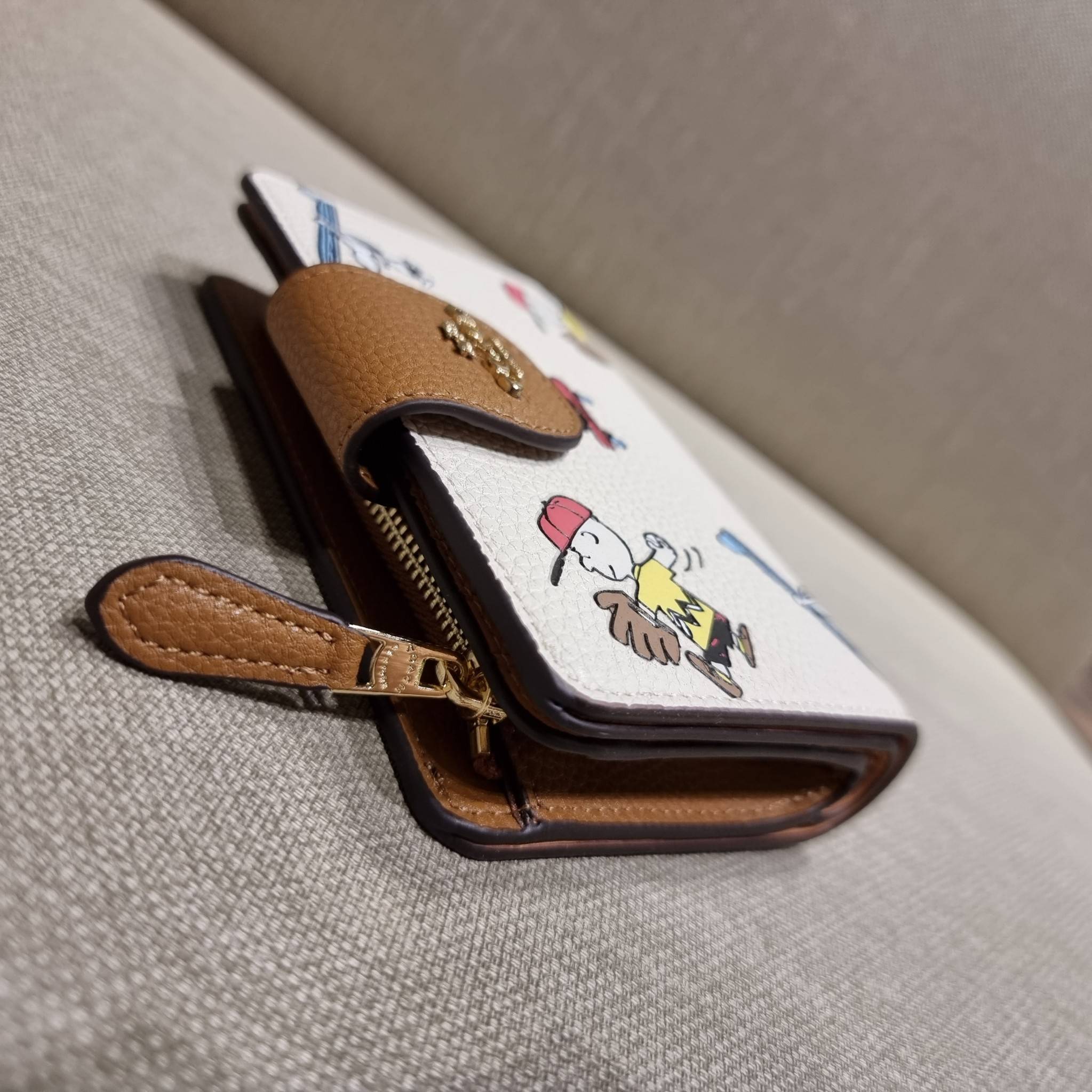 COACH C4899 MEDIUM CORNER ZIP WALLET WITH SNOPPY PRINT น้องใหม่คอลเลคชั่นสุดชิค ดีไซน์ลายพริ้นท์ผองเพื่อนสนูปพี น่ารักน่าใช้ เพิ่มลูกเล่นให้กระเป๋าสตางค์ของคุณไปอีก กับกระเป๋าสตางค์ใบกลาง ขนาดกำลังเหมาะมือ วัสดุหนัง pepble ทนทาน มีช่องใส่บัตรและธนบัตรครบ 