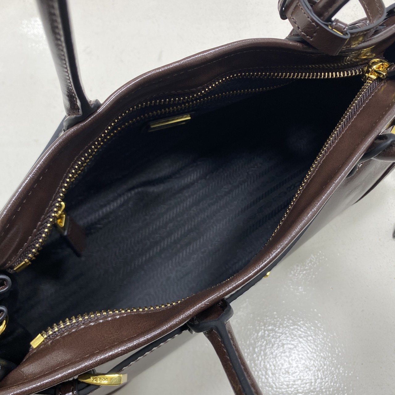 ORI หนังแท้ | Prada Bonnie medium leather handbag 32cm กระเป๋าสะพายทรงโท้ท โดดเด่นด้วยดีไซน์ที่เน้นความประณีตแต่ใช้งานได้จริง หนังเนื้อนุ่มเคลือบเงา เน้นย้ำเสน่ห์อันทันสมัยและใช้งานได้หลากหลาย