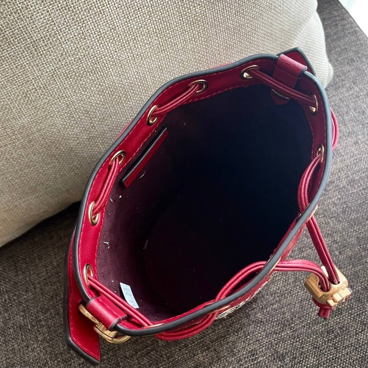 Mini : Tory Burch T Monogram Embroidered Mini Bucket Bag Hazelnut กระเป๋าทรงถังขนาดเล็ก เป็นแพทเทิร์นคลาสสิคที่ได้รับแรงบันดาลใจจากการควิลท์แบบดั้งเดิมของเพนซิลเวเนีย คอลเล็คชั่นบอกเล่าความมีสไตล์เหนือกาลเวลา ลายดอกกุหลาบสีแดงลายปักษ์ วัสดุผ้าสว๊อตซ์วินเท