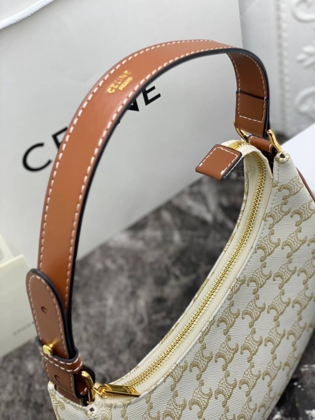 หนังแท้ CELINE AVA / CELINE Vintage Classic Ava bag 1 ใน คอลเลคชั่น “Triomphe Canvas” มาพร้อมสายสะพายไหล่ที่ปรับความยาวได้ และเนื่องจากช่วงล่างของกระเป๋ามีขนาดใหญ่กว่าช่วงบน จึงทำให้ไม่เสียทรงเมื่อเราใส่สิ่งของอย่างกระเป๋าสตางค์หรือโทรศัพท์มือถือ หากดูภาพ