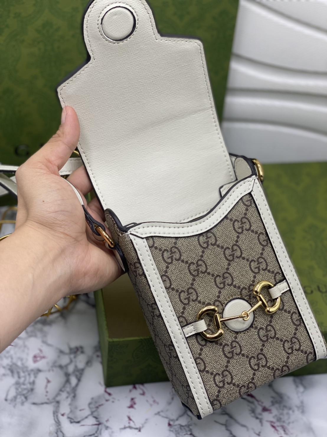 หนังแท้ GUCCI Horsebit phone bag กระเป๋าสะพาย กระเป๋าใส่โทรศัพท์สุดคลาสสิก หนังวัวแท้สีน้ำตาล/สีขาว อะไหล่ทองสวย ดีไซต์สัญลักษณ์วงแหวนตามแบบฉบับแบรนด์ สายสะพายยาวที่สามารถปรับระดับได้ ภาพสินค้าถ่ายจากงานขายจริง ใช้งานต่างประเทศได้ค่ะ